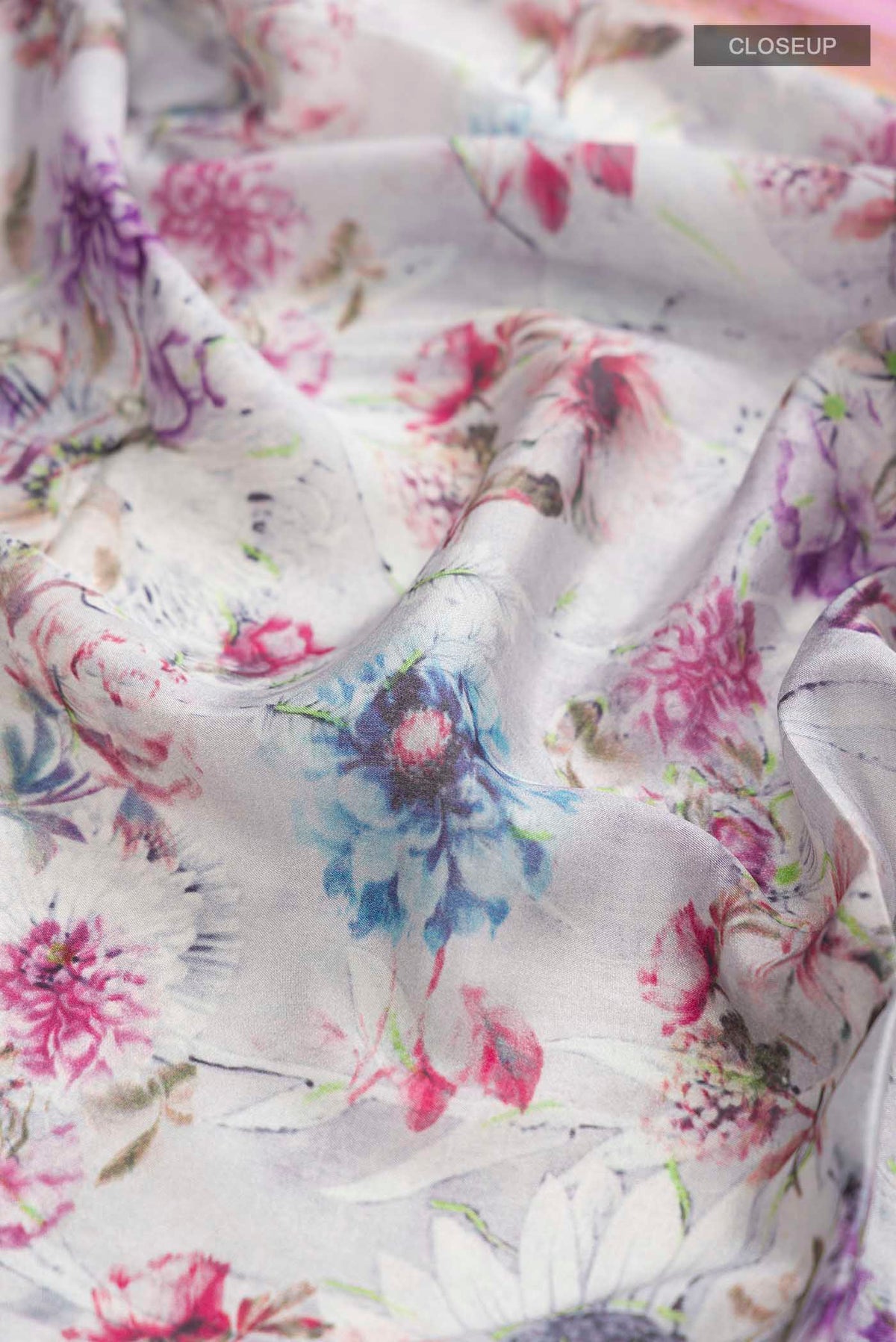 Close up of Grey Mysore Crepe Saree with Floral Print on the body and Zari Border displaying folds