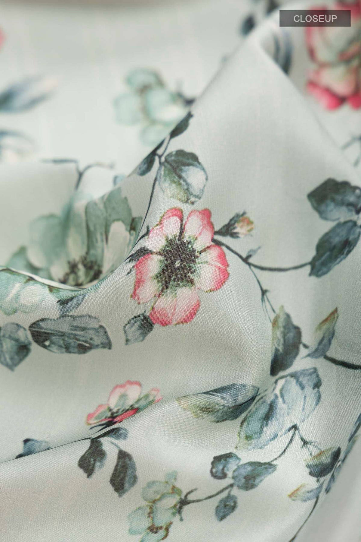 Close up of Green Mysore Crepe Saree with Printed design on the body and Zari Border displaying folds