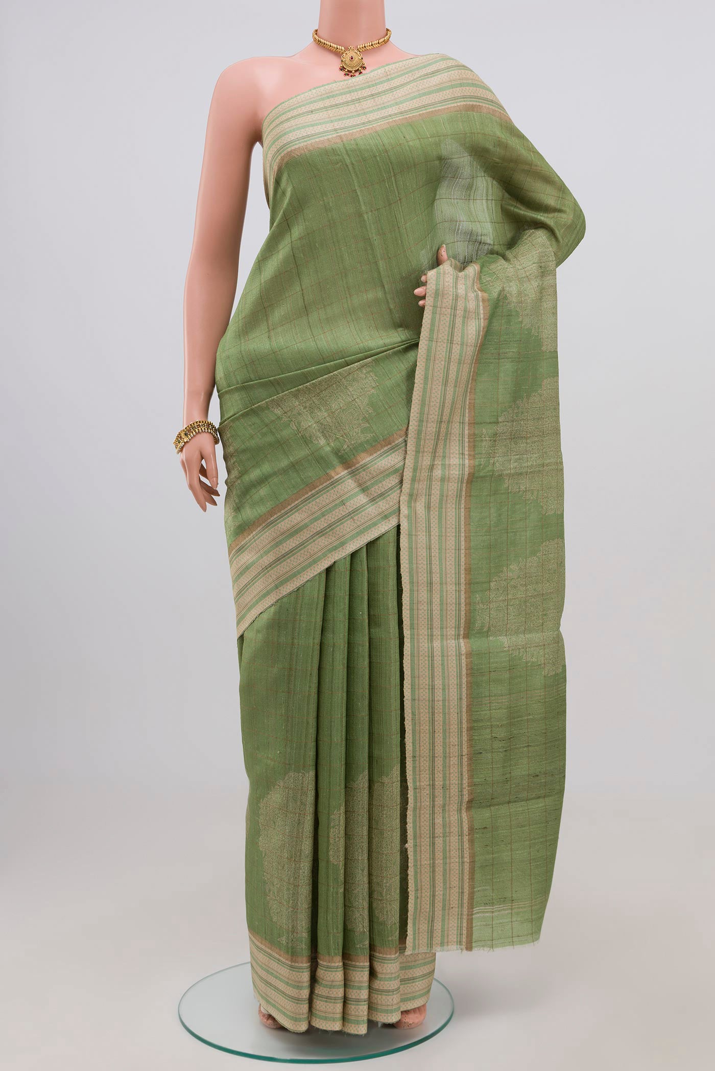 Green Tussar Silk Saree with Fancy on the body and Thin Zari Line.  displayed on a mannequin