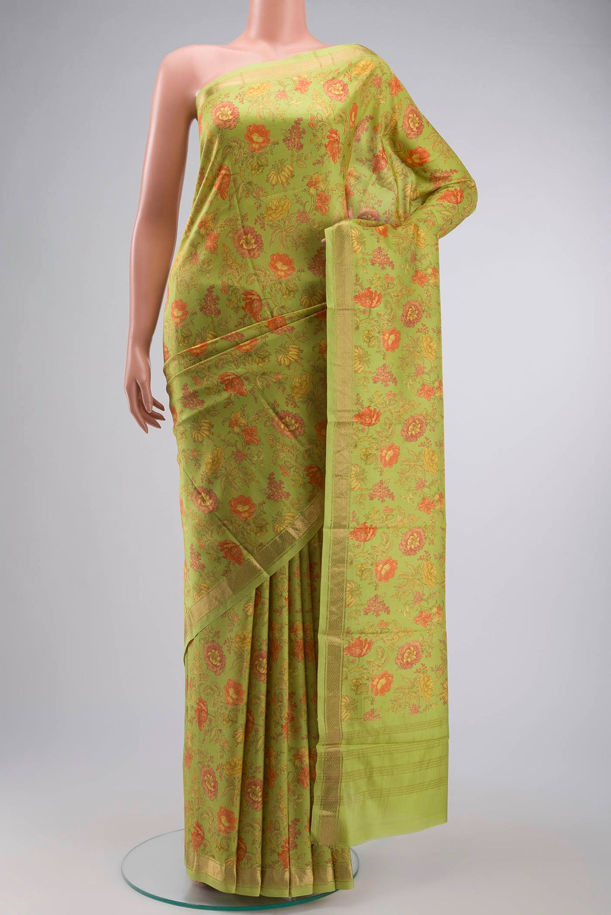 Green Printed Silk Saree with Floral Print on the body and Zari Border displayed on a mannequin