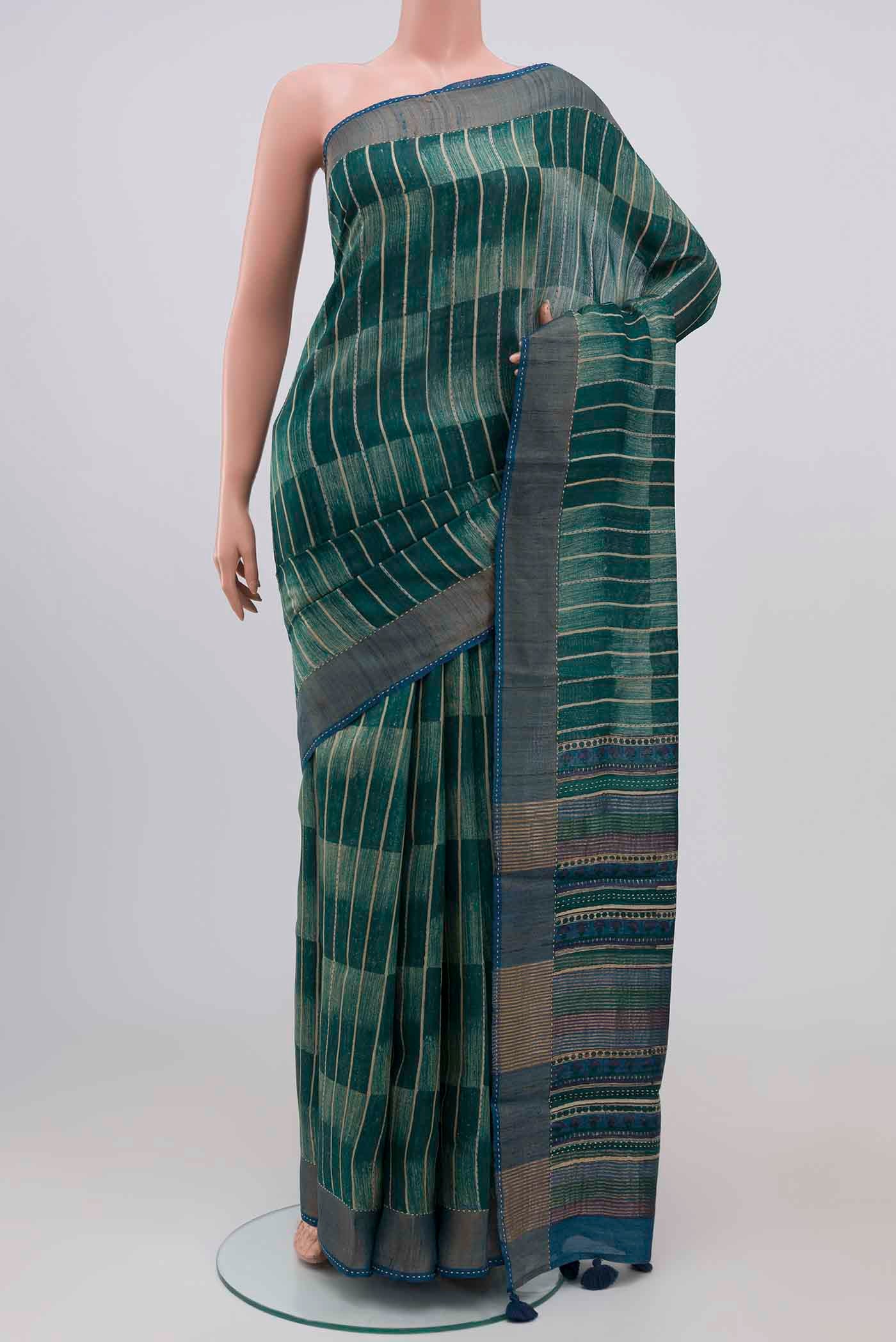 Green Tussar Silk Saree with Printed design on the body and Zari Border.  displayed on a mannequin
