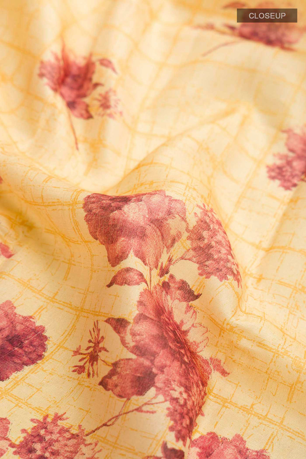 Close up of Mustard Tussar Silk Saree with Printed design on the body and Zari Border displaying folds