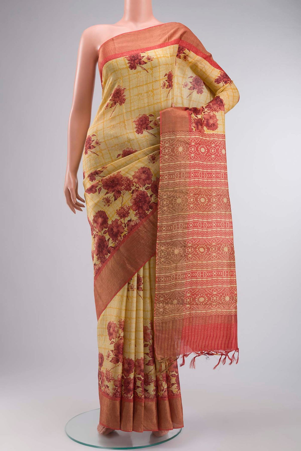 Mustard Tussar Silk Saree with Printed design on the body and Zari Border displayed on a mannequin