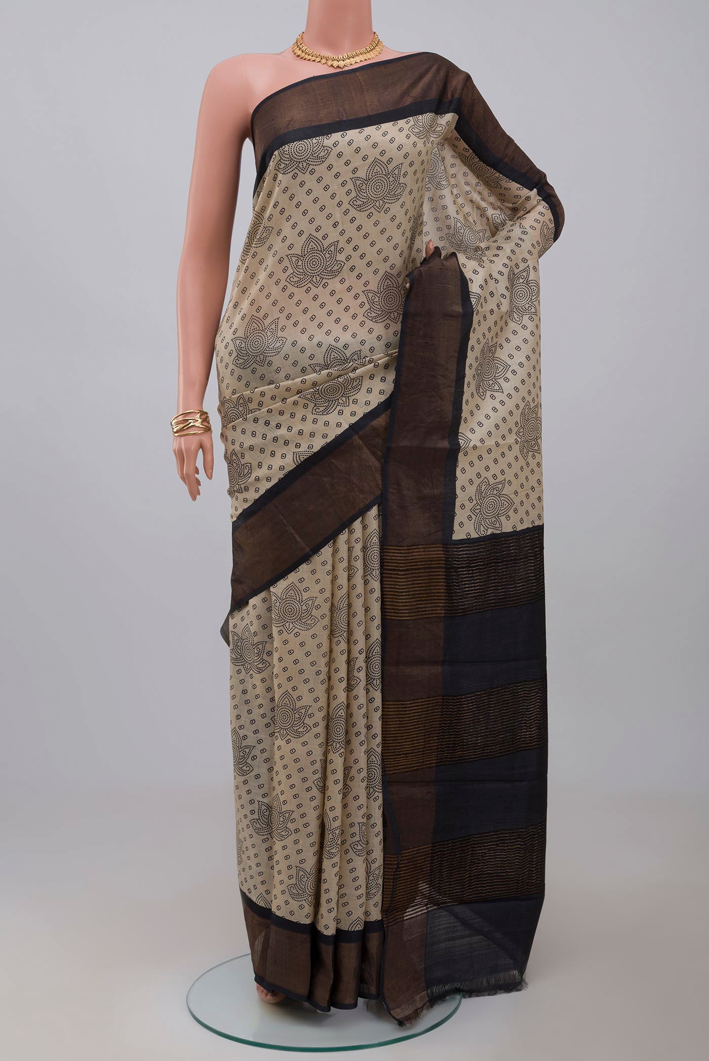 Cream Tussar Silk Saree with Printed design on the body and Zari Border.  displayed on a mannequin