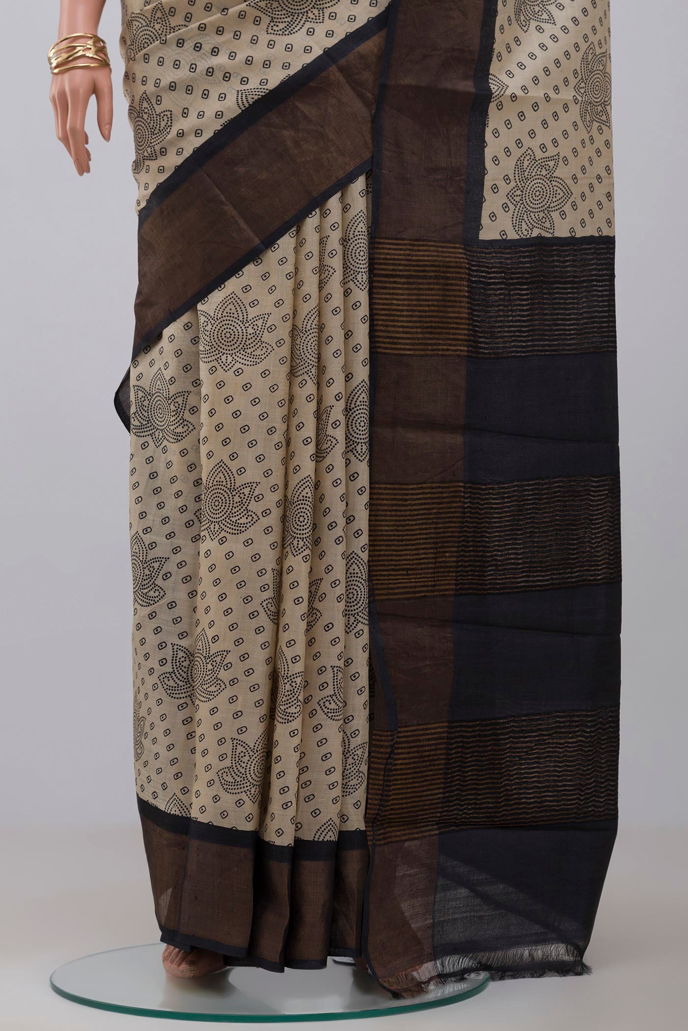 Pleats and pallu of Cream Tussar Silk Saree with Printed design on the body and Zari Border. 