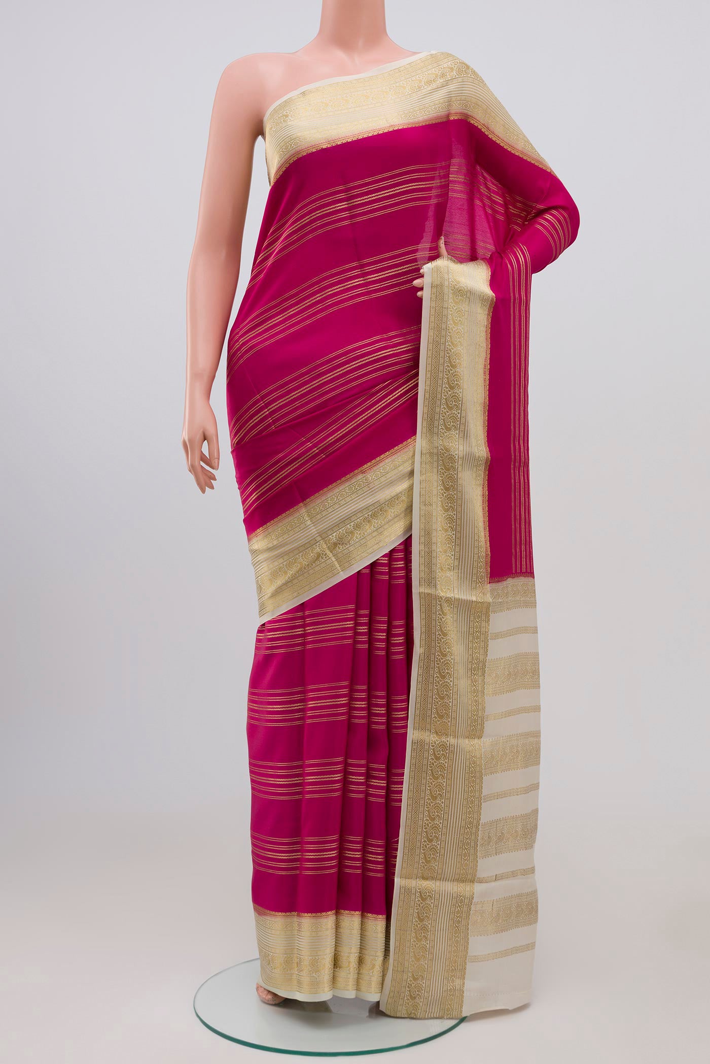 Magenta Mysore Silk Saree with Stripes on the body and Zari Border.  displayed on a mannequin