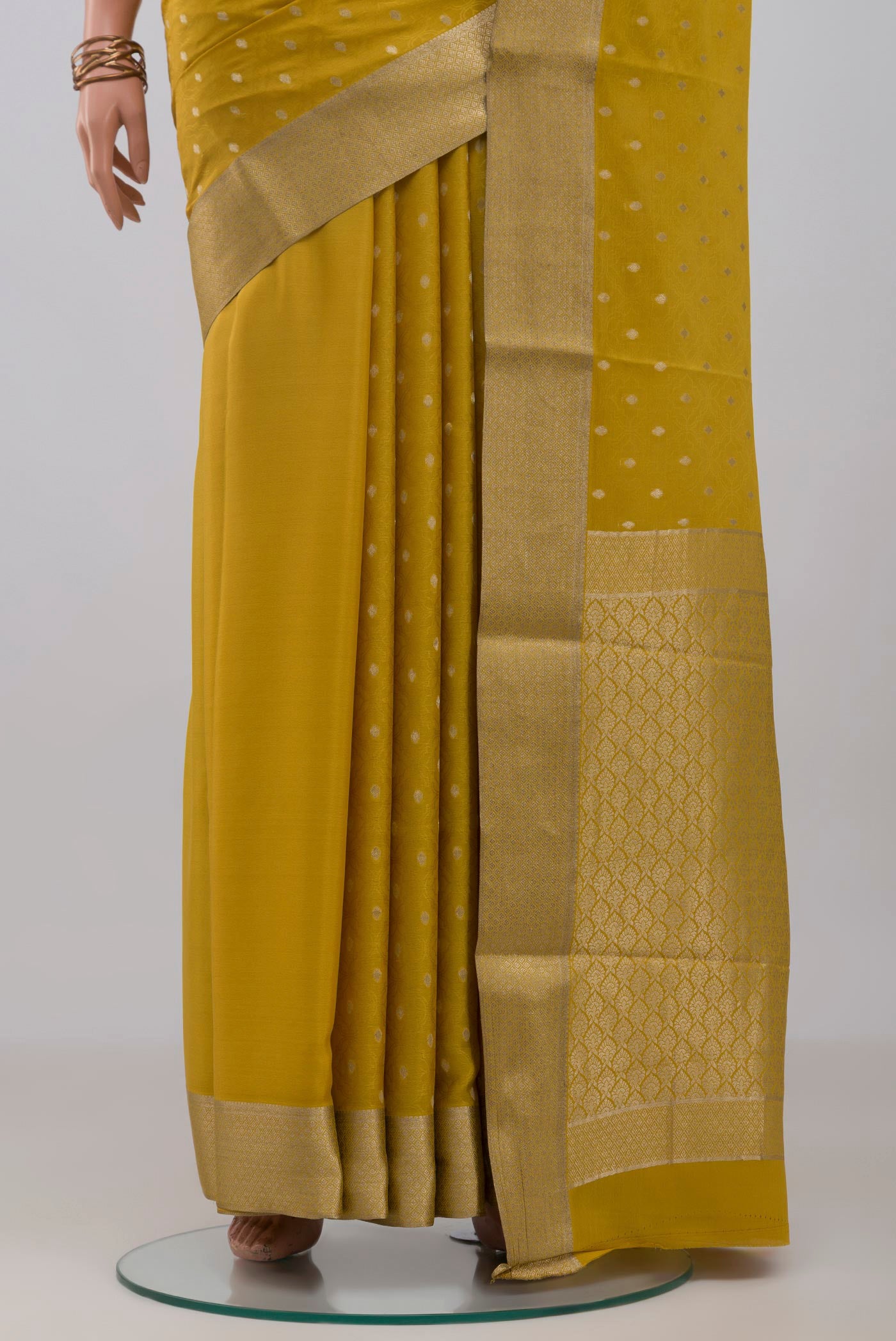 Pleats and pallu of Yellow Mysore Crepe Saree with Jacquard With Zari Butta on the body and Zari Border. 