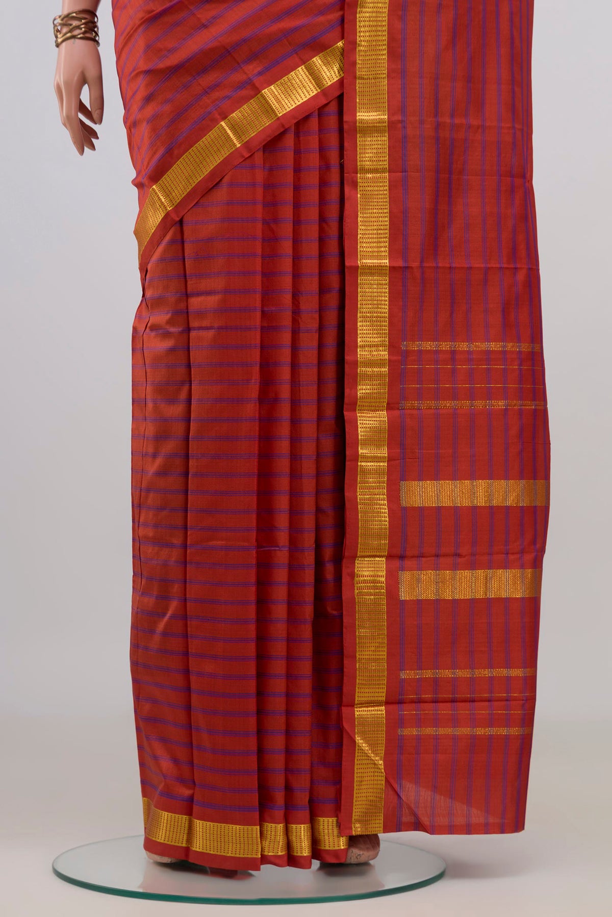Pleats and pallu of Pure Silk Orange Kanchipuram Saree with Stripes on the body and Zari Border. 