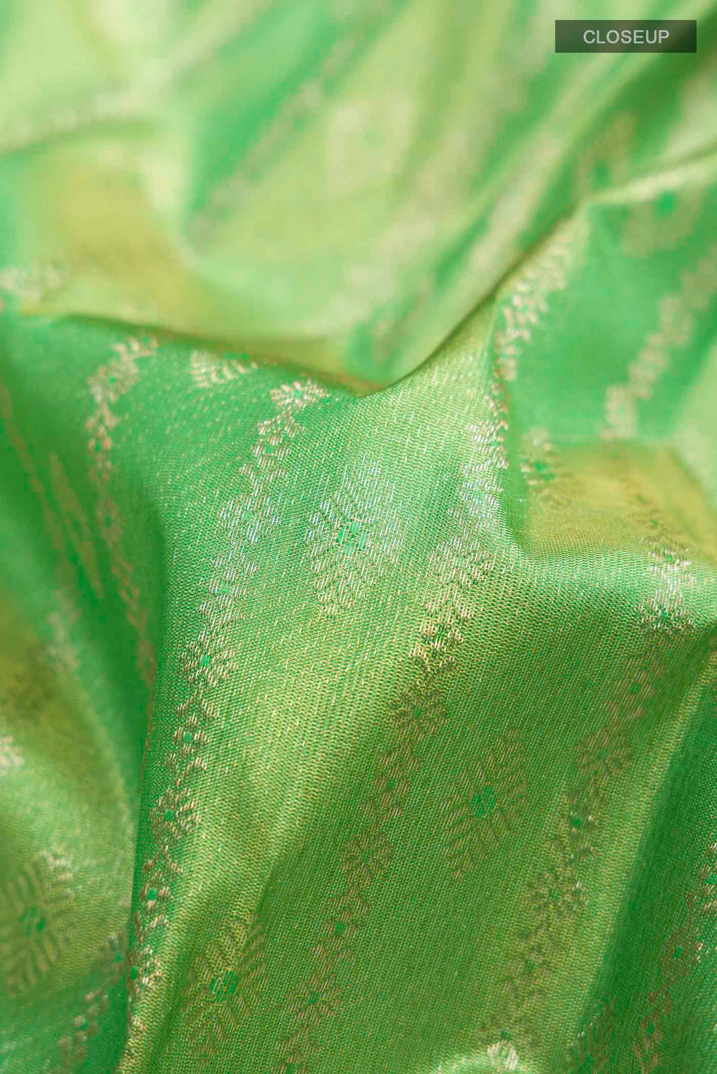 Close up of Green Kanchipuram Silk Saree with Zari Butta on the body and Zari Border displaying folds