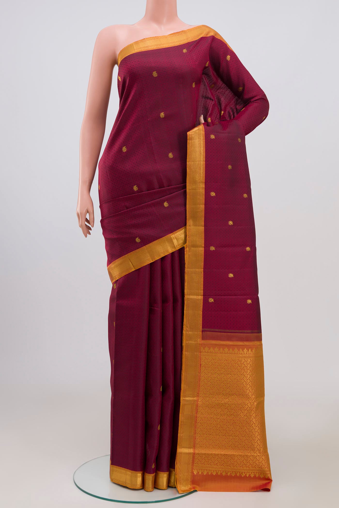 Maroon Kanchipuram Saree with Jacquard With Zari Butta on the body and Zari Border.  displayed on a mannequin