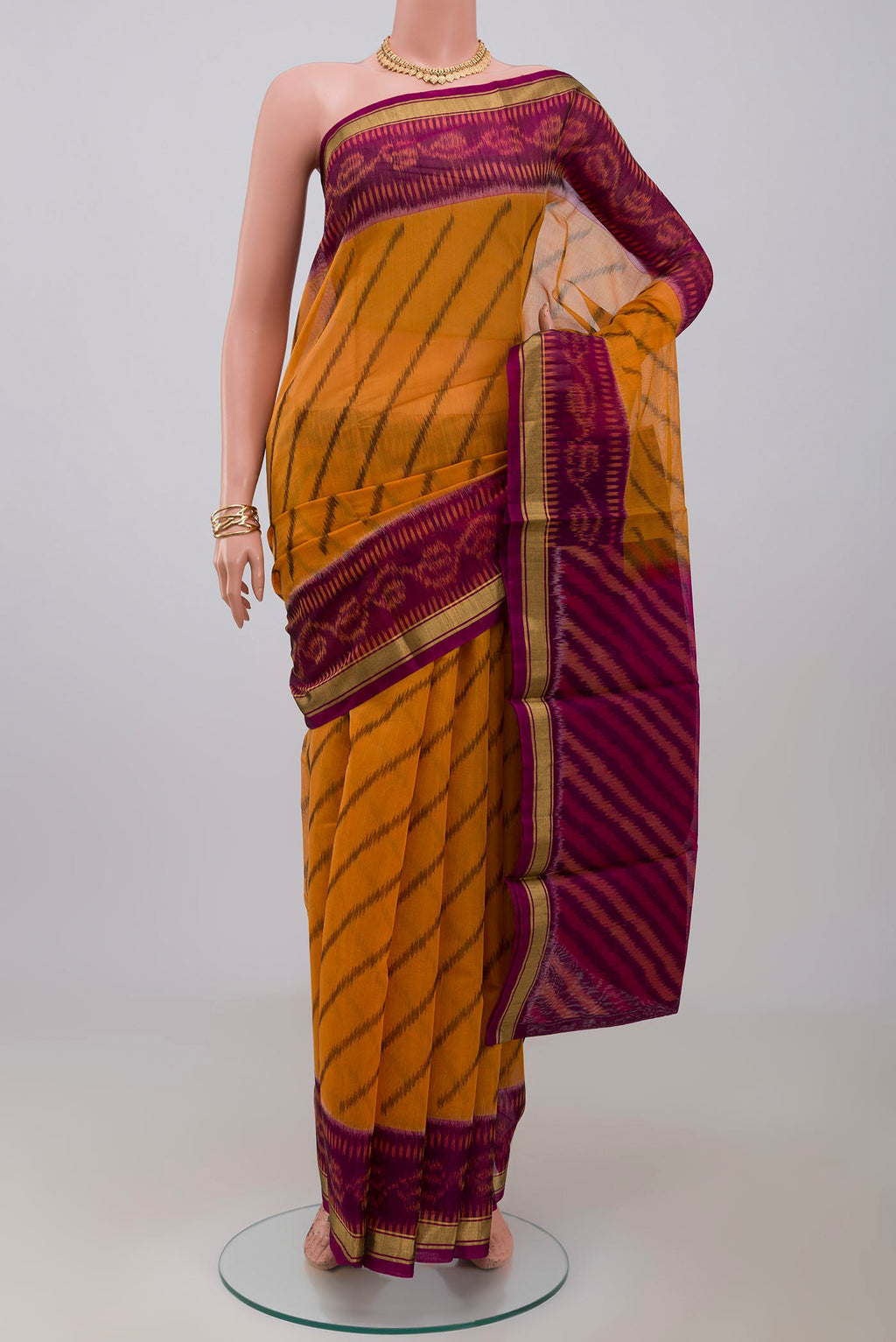 Yellow Silk Cotton Saree with Ikat Print on the body and Thin Zari Line.  displayed on a mannequin