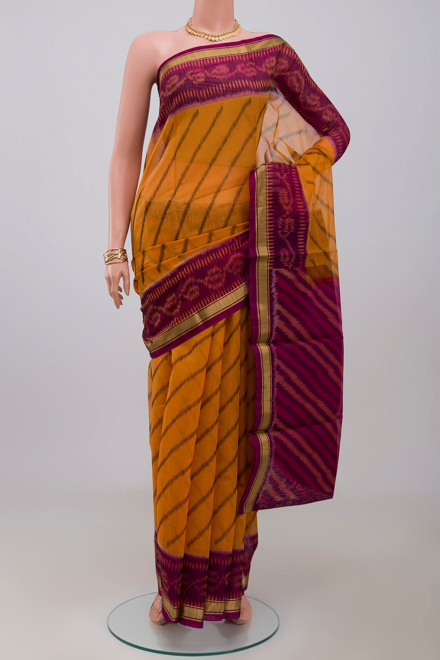 Yellow Silk Cotton Saree with Ikat Print on the body and Thin Zari Line.  displayed on a mannequin