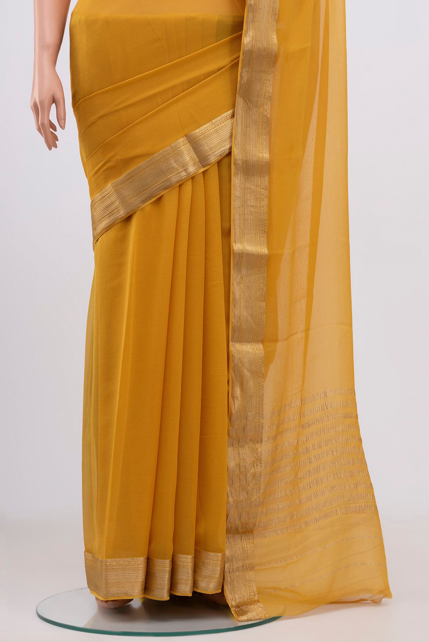 Pleats and pallu of Yellow Chiffon Saree with Plain Body and Zari Border. 