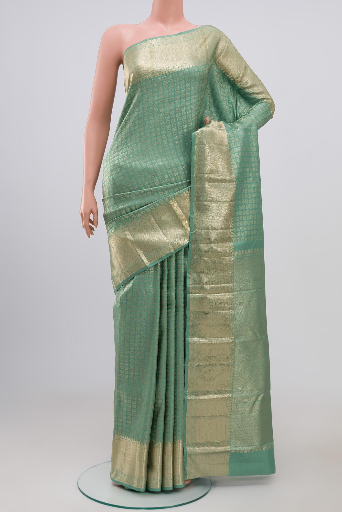 Light Green Kanchipuram Silk Saree with Zari Brocade on the body and Zari Border.  displayed on a mannequin