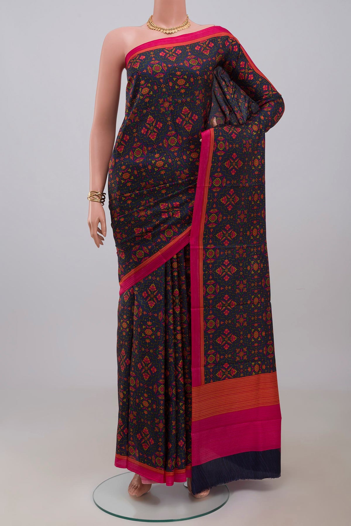 Navy Blue Printed Silk Saree with Printed design on the body and Plain Border.  displayed on a mannequin