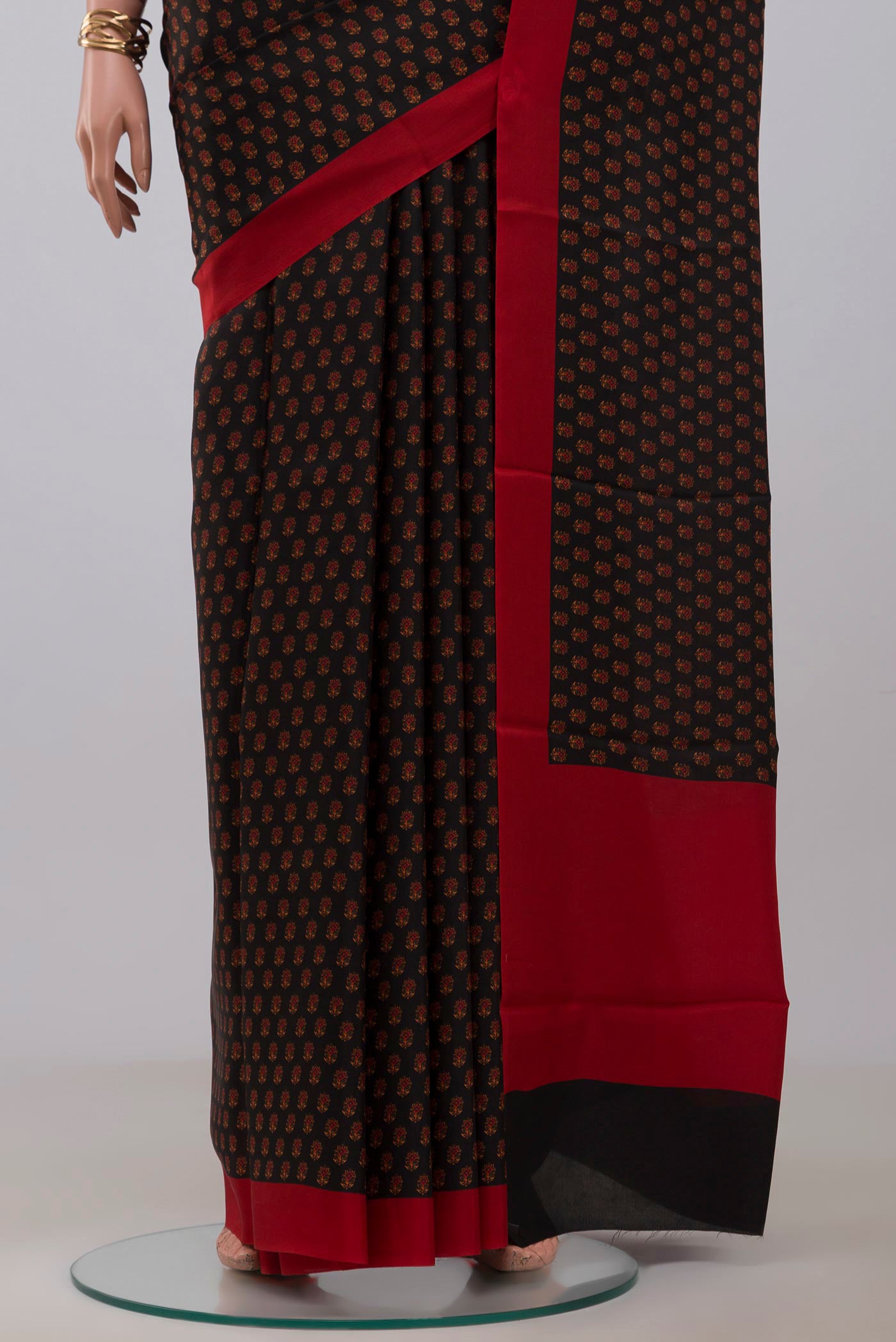 Pleats and pallu of Black Printed Silk Saree with Printed design on the body and Plain Border. 