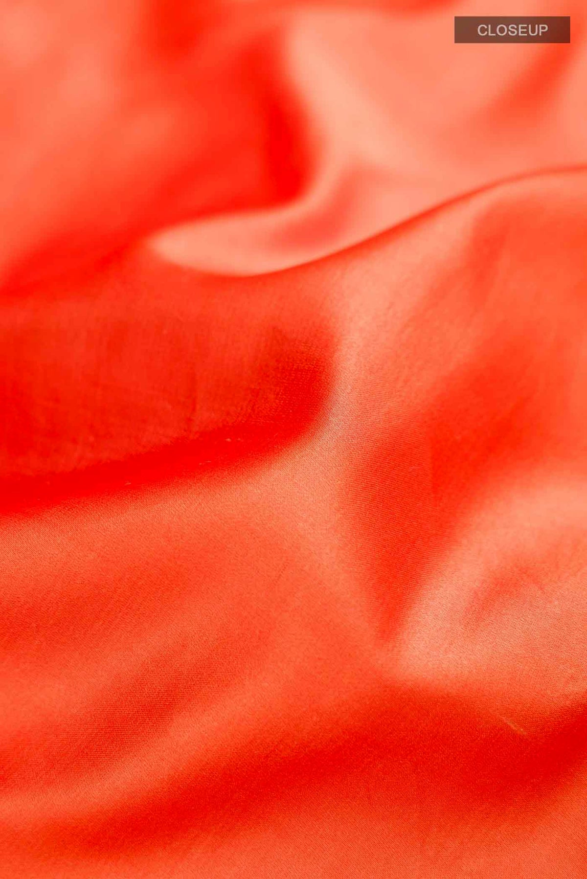 Close up of Orange Banarasi Silk Saree with Plain Body and Thread Border displaying folds