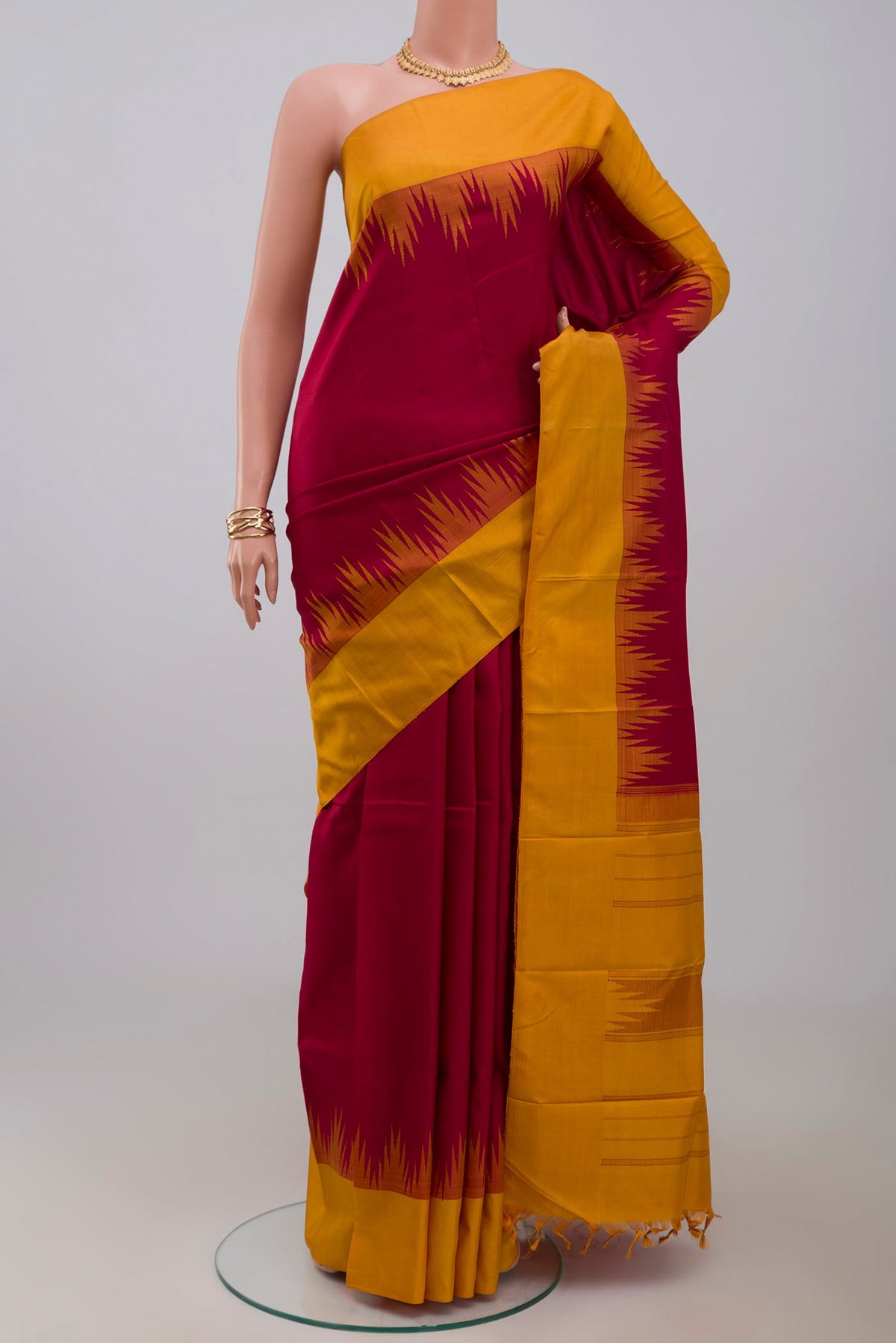 Maroon Kanjivaram Silk Saree with Plain Body and Temple Border.  displayed on a mannequin