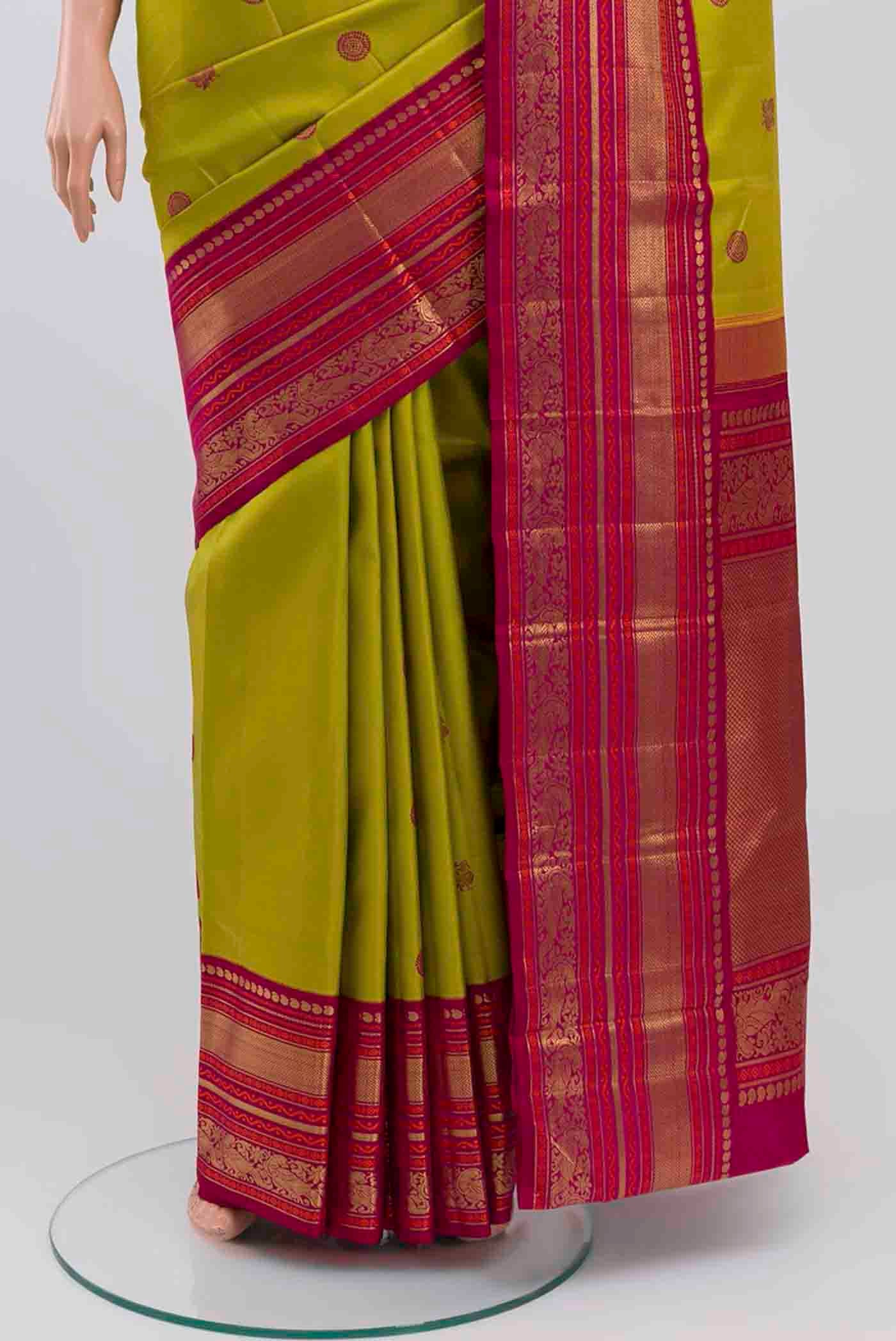 Pleats and pallu of Pure Silk Pure Zari Parrot Green Kanchipuram Saree with Thread Butta on the body and Zari Border