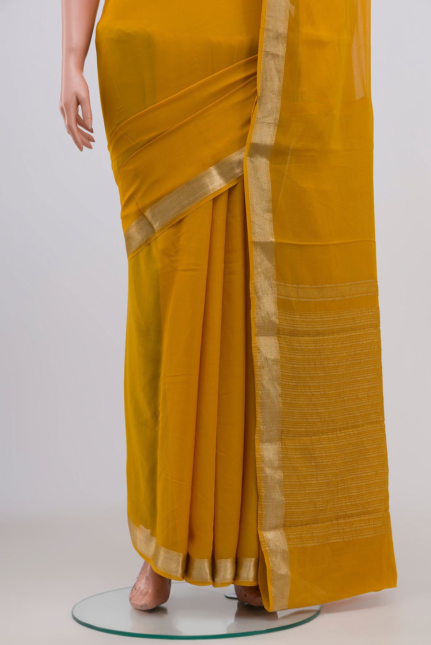 Pleats and pallu of Yellow Chiffon Saree with Plain Body and Zari Border. 