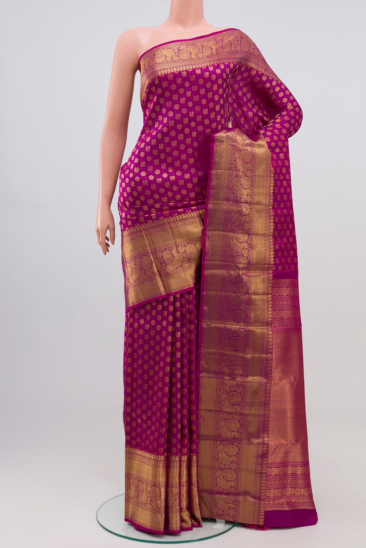 Magenta Kanchipuram Silk Saree with Zari Brocade on the body and Zari Border.  displayed on a mannequin