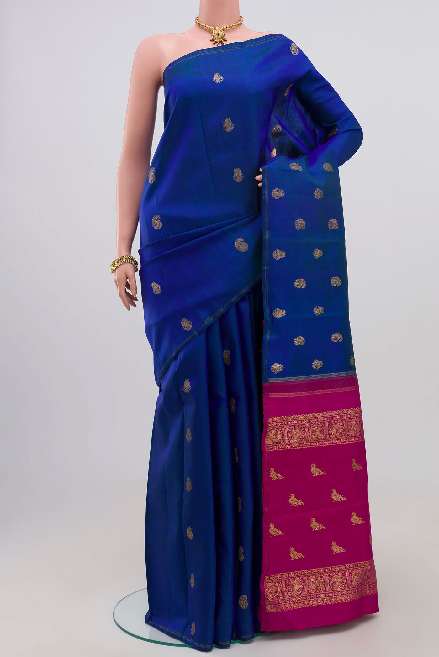 Pure Silk Pure Zari Blue Kanchipuram Saree with Zari Butta on the body and Thin Zari Line.  displayed on a mannequin