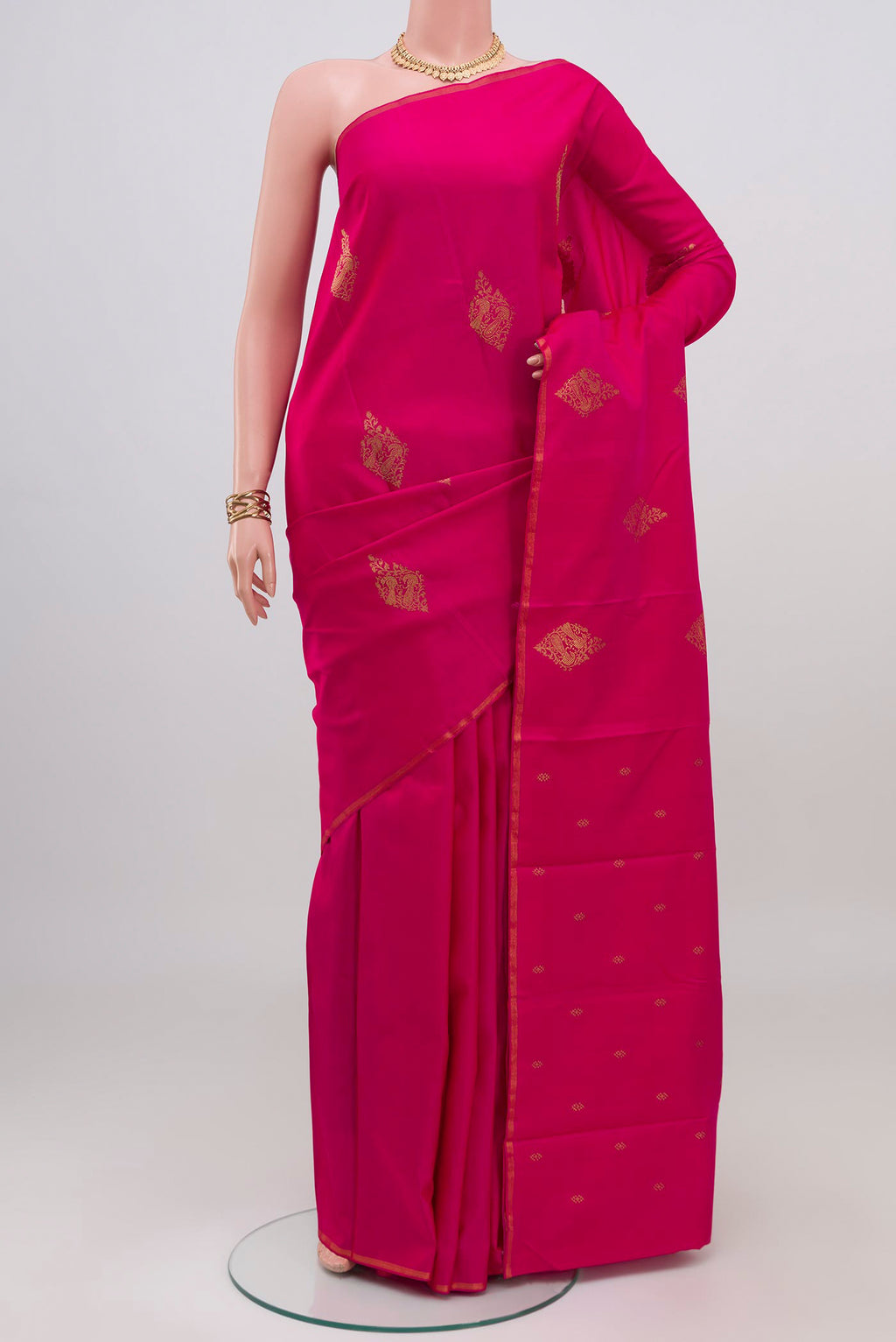 Pink Kanchipuram Silk Saree with Zari Butta on the body and Thin Zari Line.  displayed on a mannequin