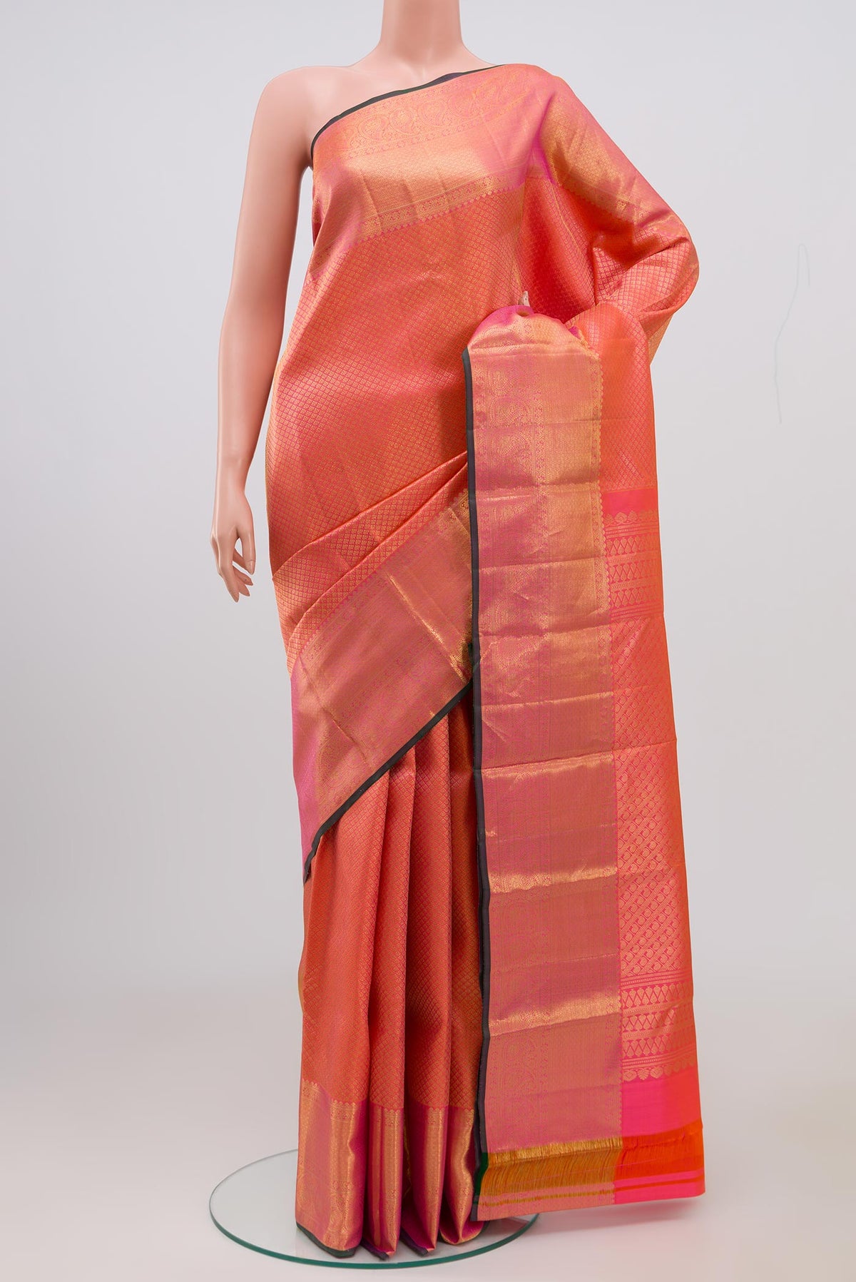 Orange Kanjivaram Saree with Zari Brocade on the body and Zari Border.  displayed on a mannequin