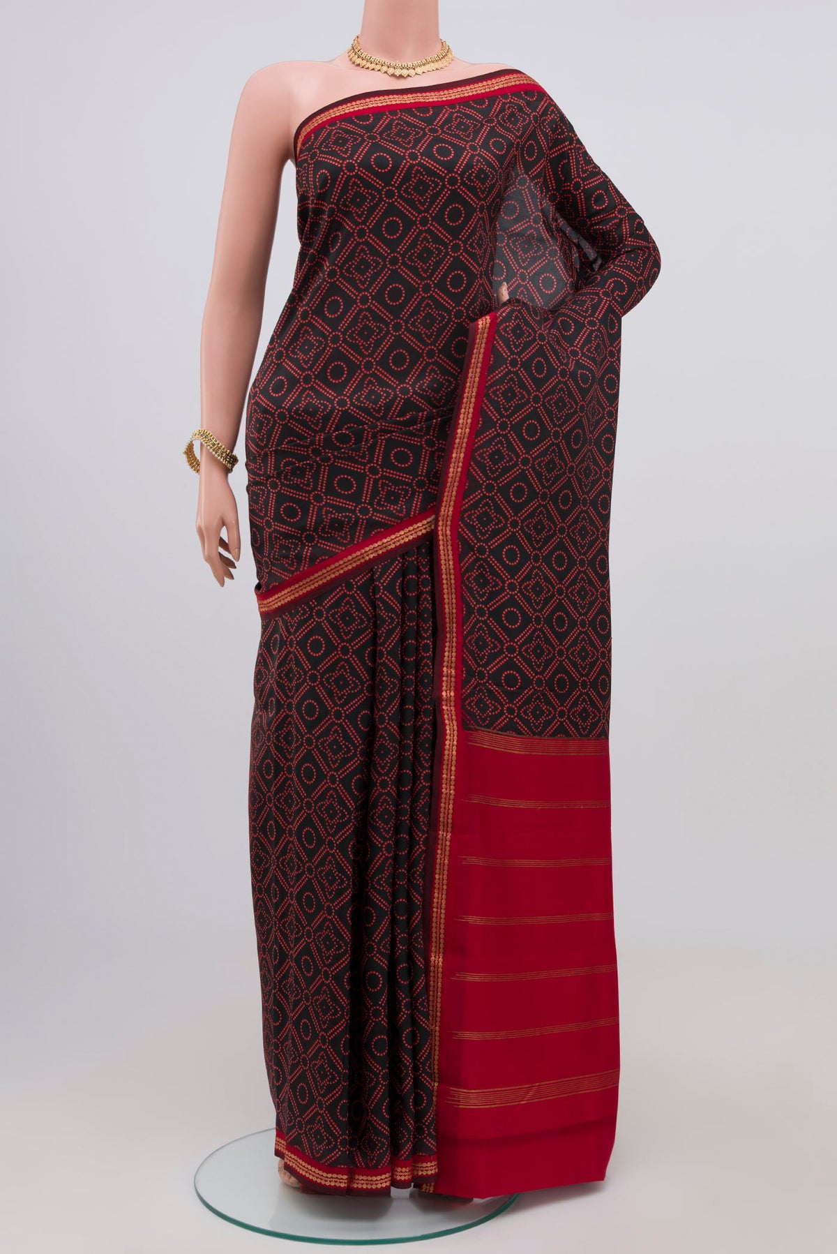 Black Printed Silk Saree with Printed design on the body and Zari Border.  displayed on a mannequin
