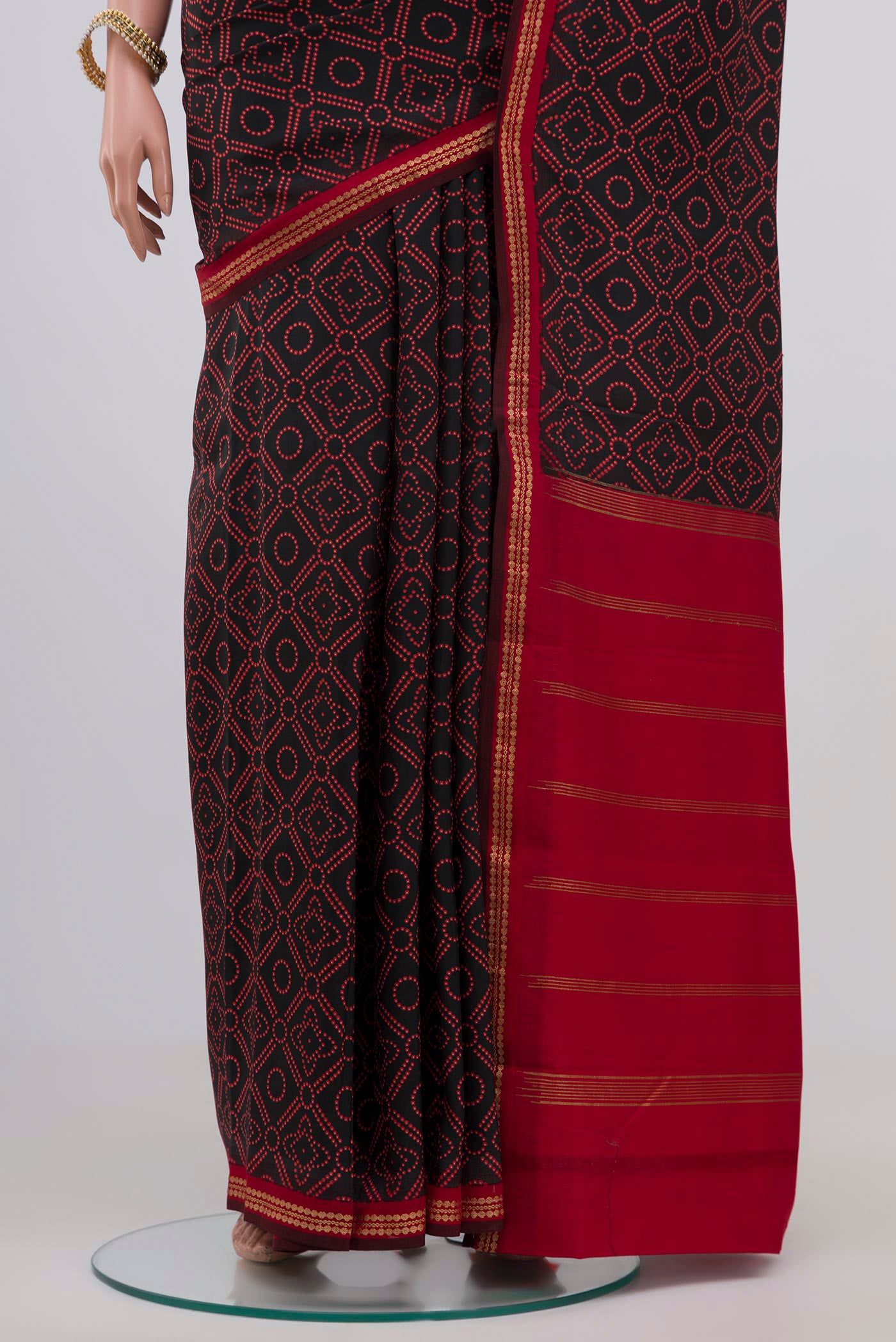 Pleats and pallu of Black Printed Silk Saree with Printed design on the body and Zari Border. 