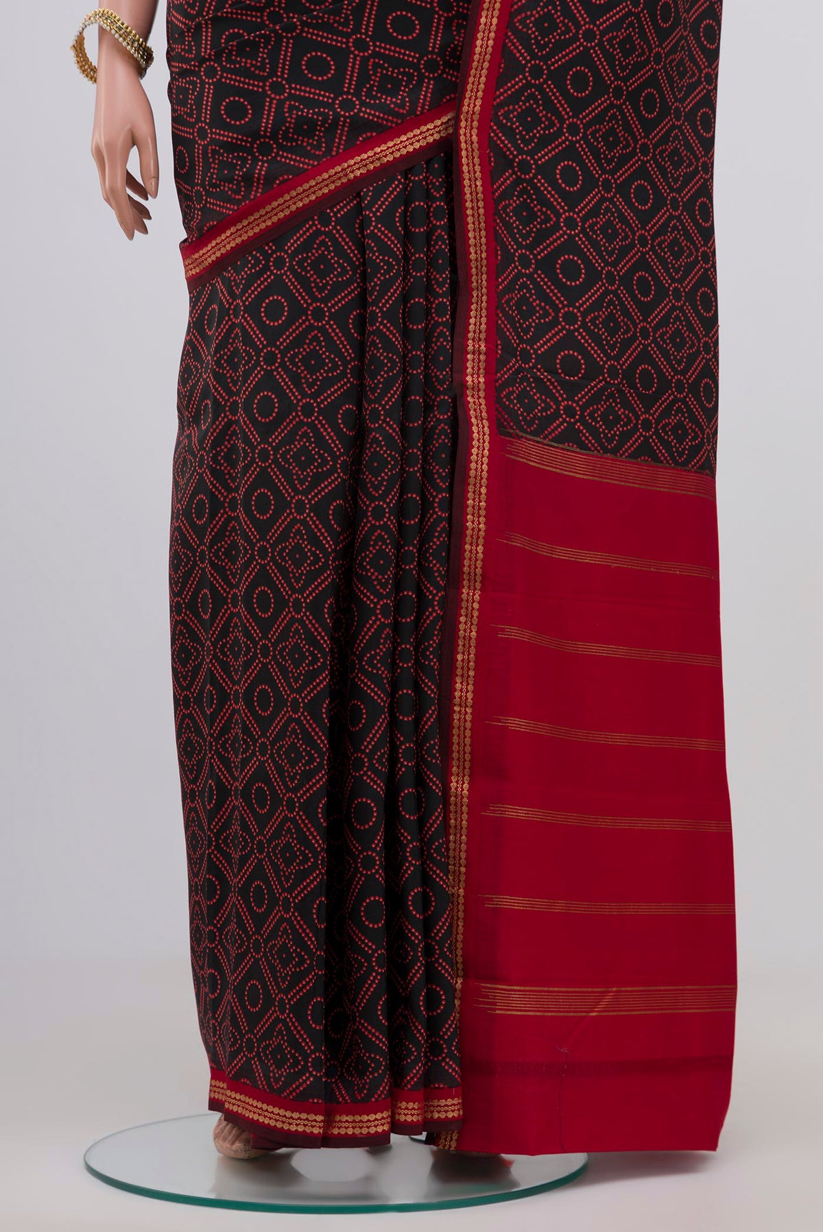 Pleats and pallu of Black Printed Silk Saree with Printed design on the body and Zari Border. 