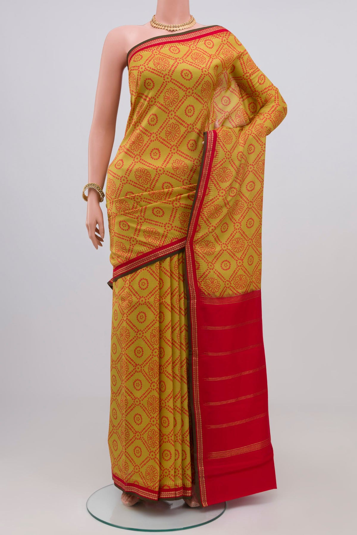 Yellow Printed Silk Saree with Printed design on the body and Zari Border.  displayed on a mannequin