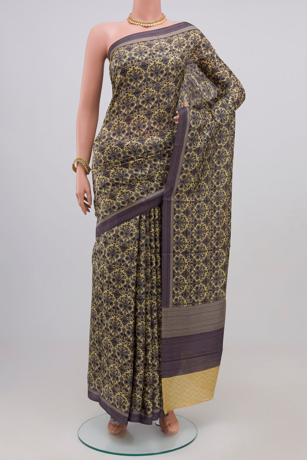 Beige Printed Silk Saree with Printed design on the body and Plain Border.  displayed on a mannequin