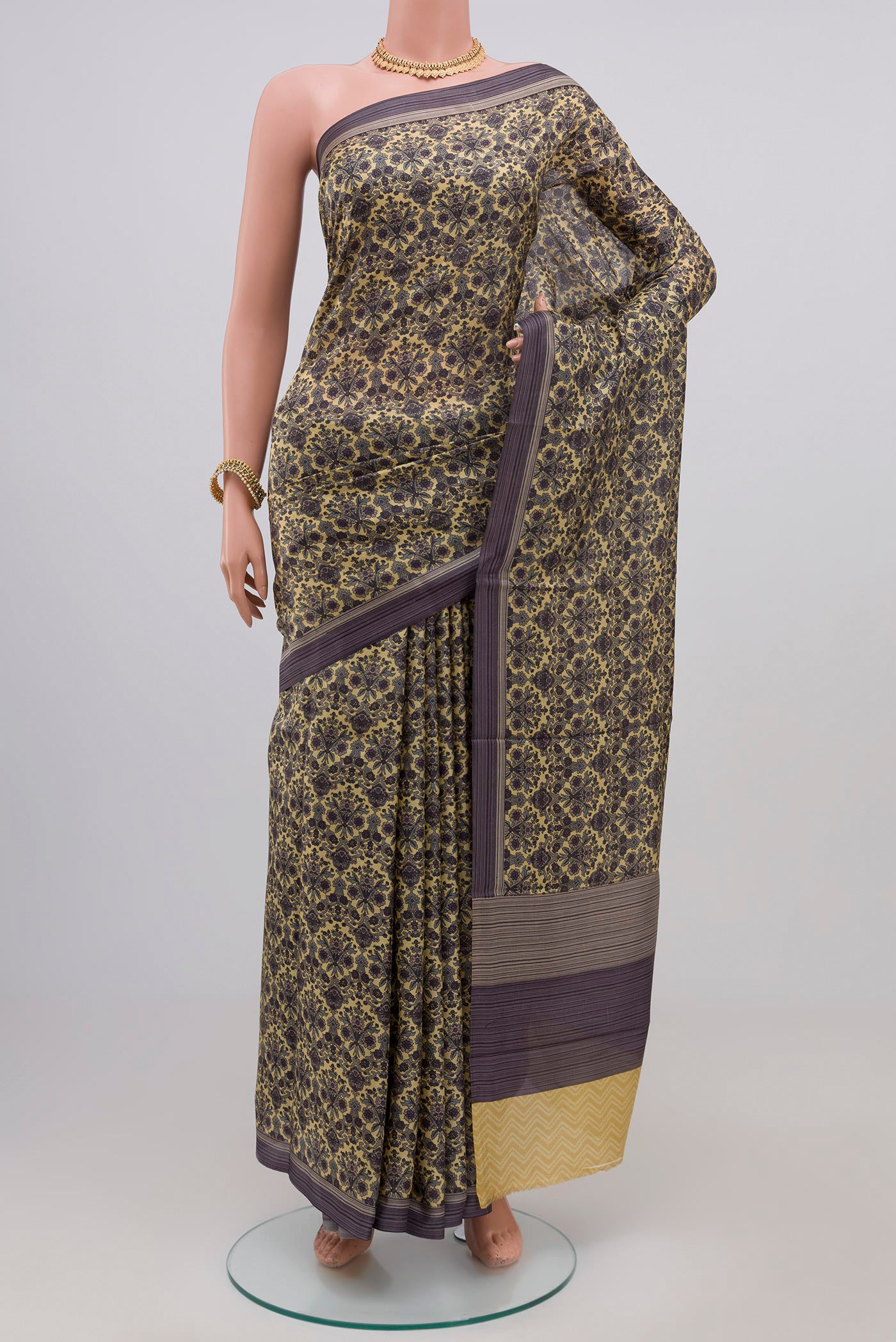 Beige Printed Silk Saree with Printed design on the body and Plain Border.  displayed on a mannequin