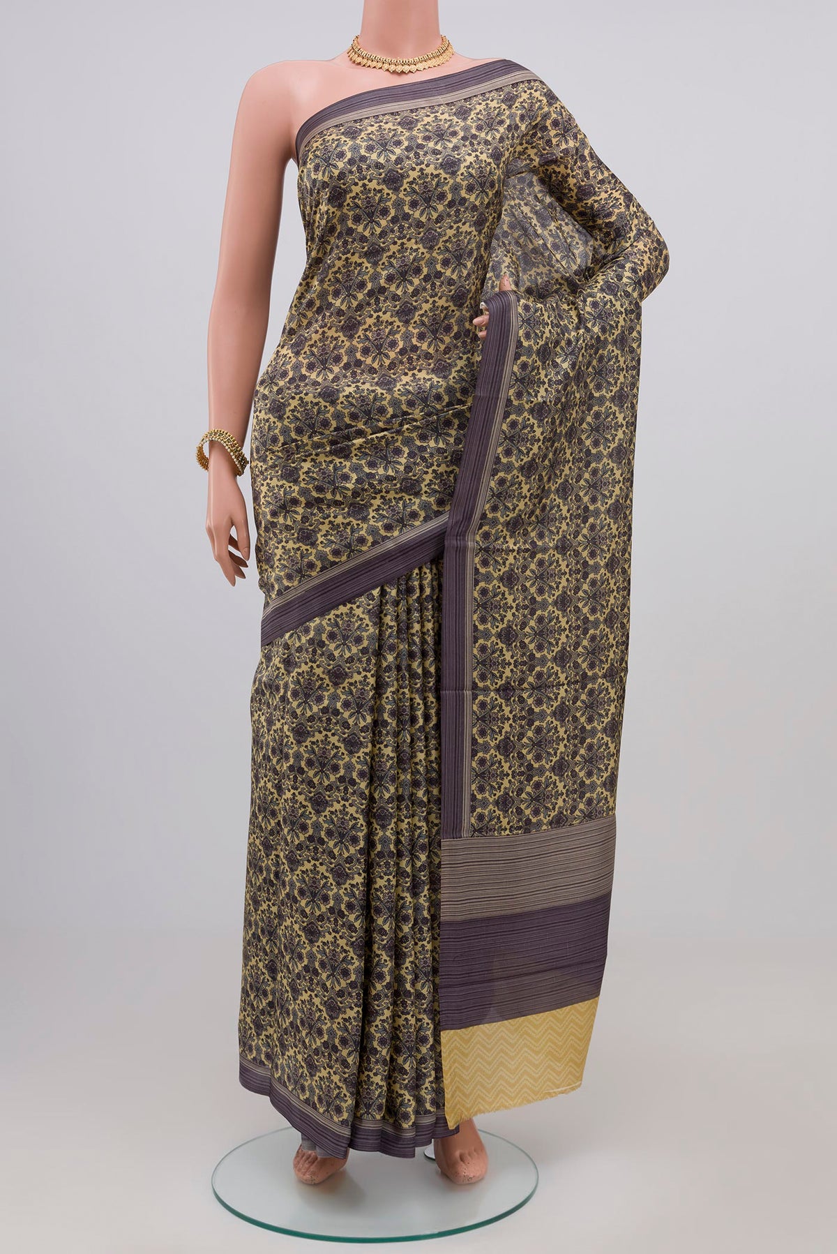 Beige Printed Silk Saree with Printed design on the body and Plain Border.  displayed on a mannequin