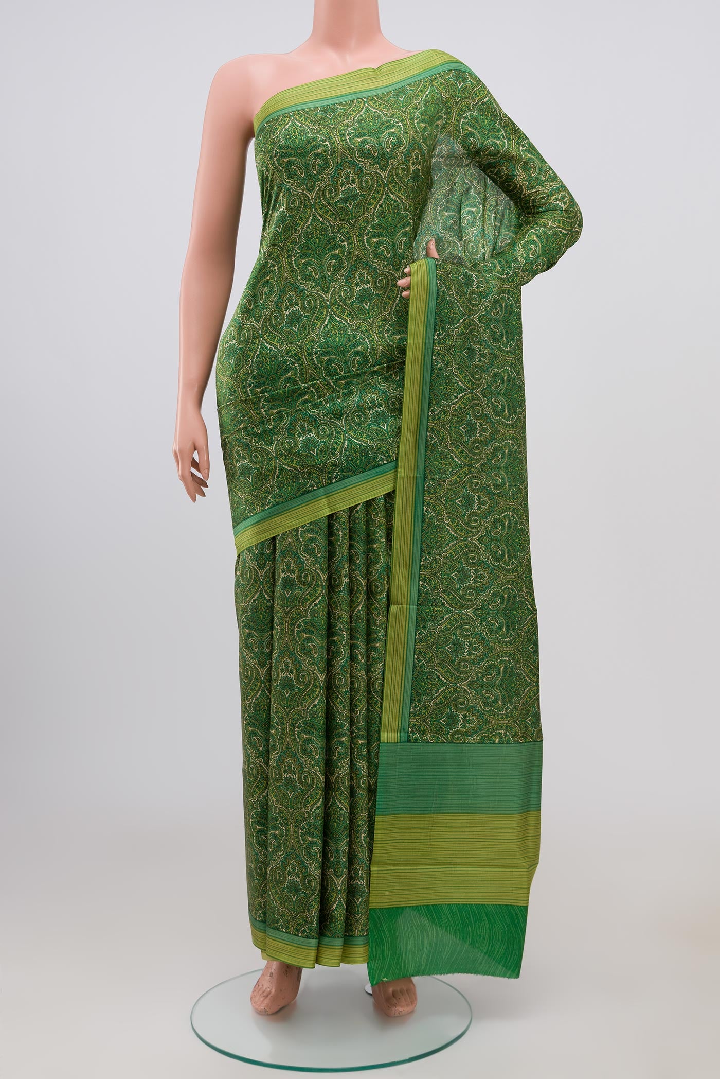 Green Printed Silk Saree with Printed design on the body and Plain Border.  displayed on a mannequin