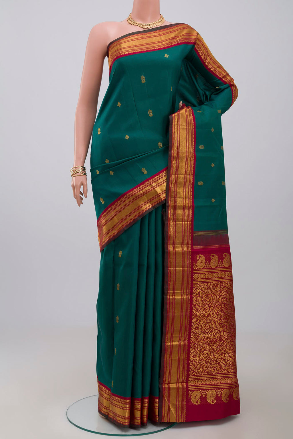 Pure Silk Pure Zari Green Kanchipuram Saree with Zari Butta on the body and Zari Border.  displayed on a mannequin
