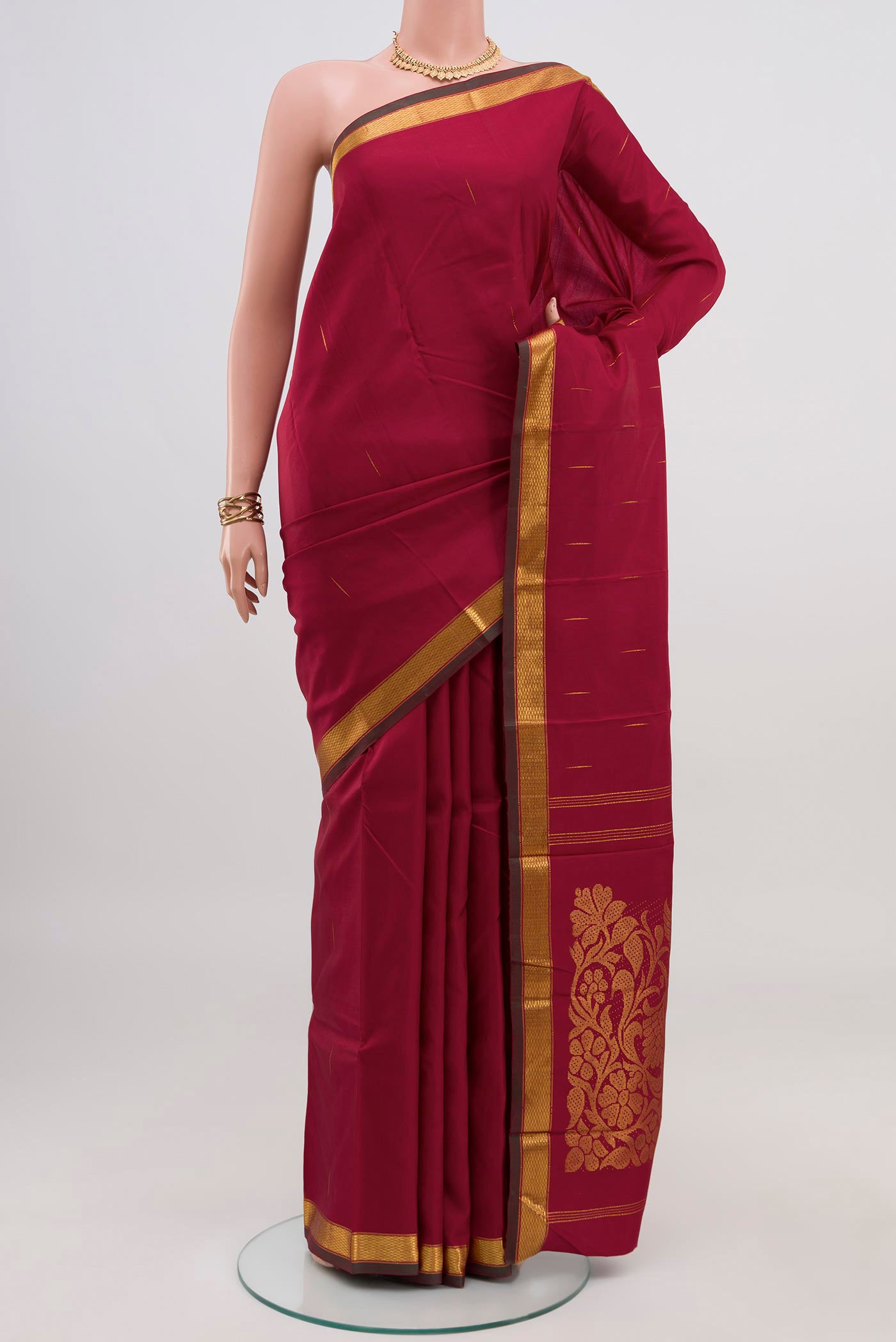 Pure Silk Pure Zari Maroon Kanjivaram Saree with Zari Butta on the body and Zari Border.  displayed on a mannequin