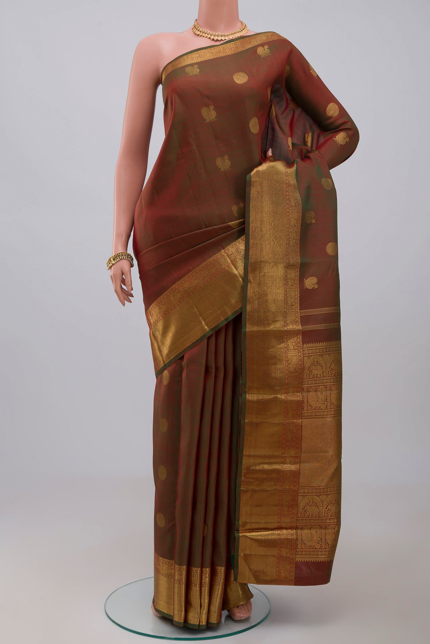 Pure Silk Pure Zari Green Kanchipuram Saree with Zari Butta on the body and Zari Border.  displayed on a mannequin
