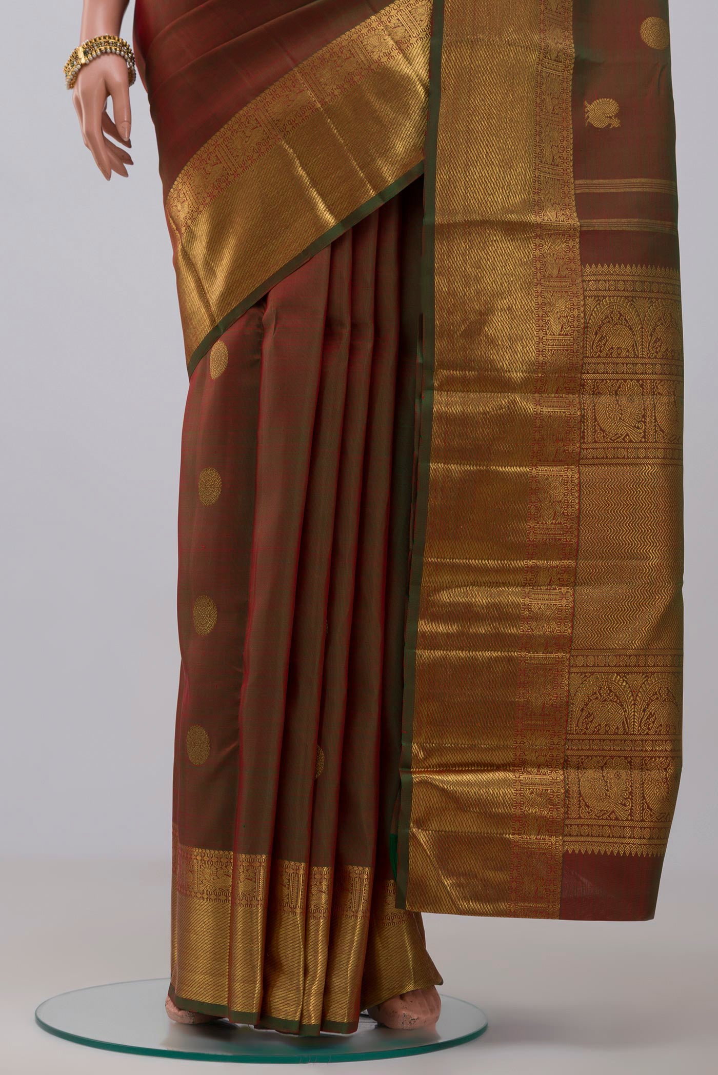 Pleats and pallu of Pure Silk Pure Zari Green Kanchipuram Saree with Zari Butta on the body and Zari Border. 