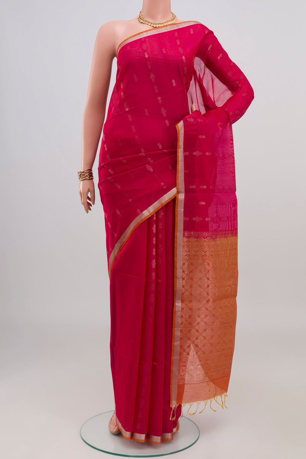 Pink Silk Cotton Saree with Zari Butta on the body and Thin Zari Line.  displayed on a mannequin