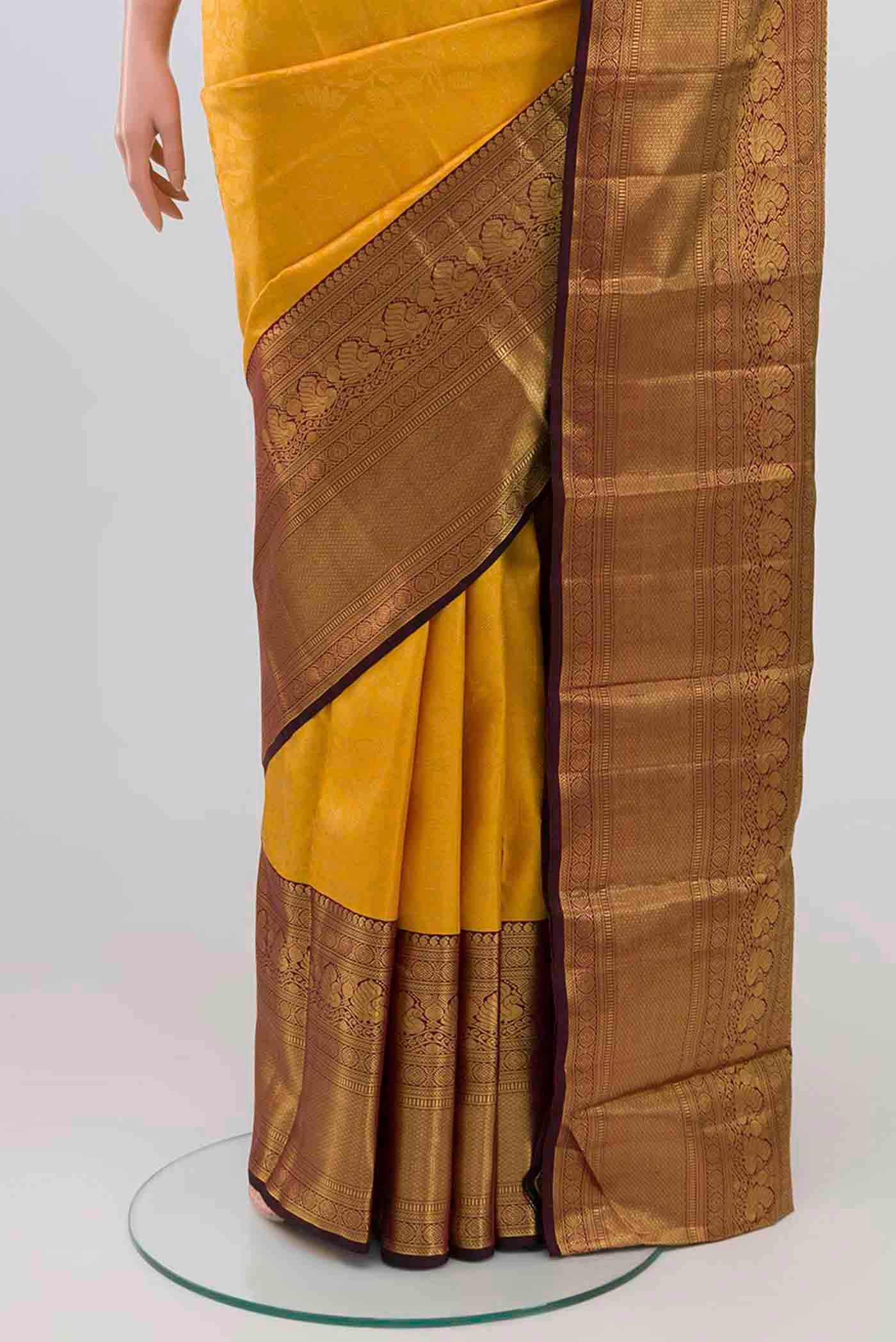 Pleats and pallu of Mustard Kanchipuram Silk Saree with Zari Brocade on the body and Zari Border. 