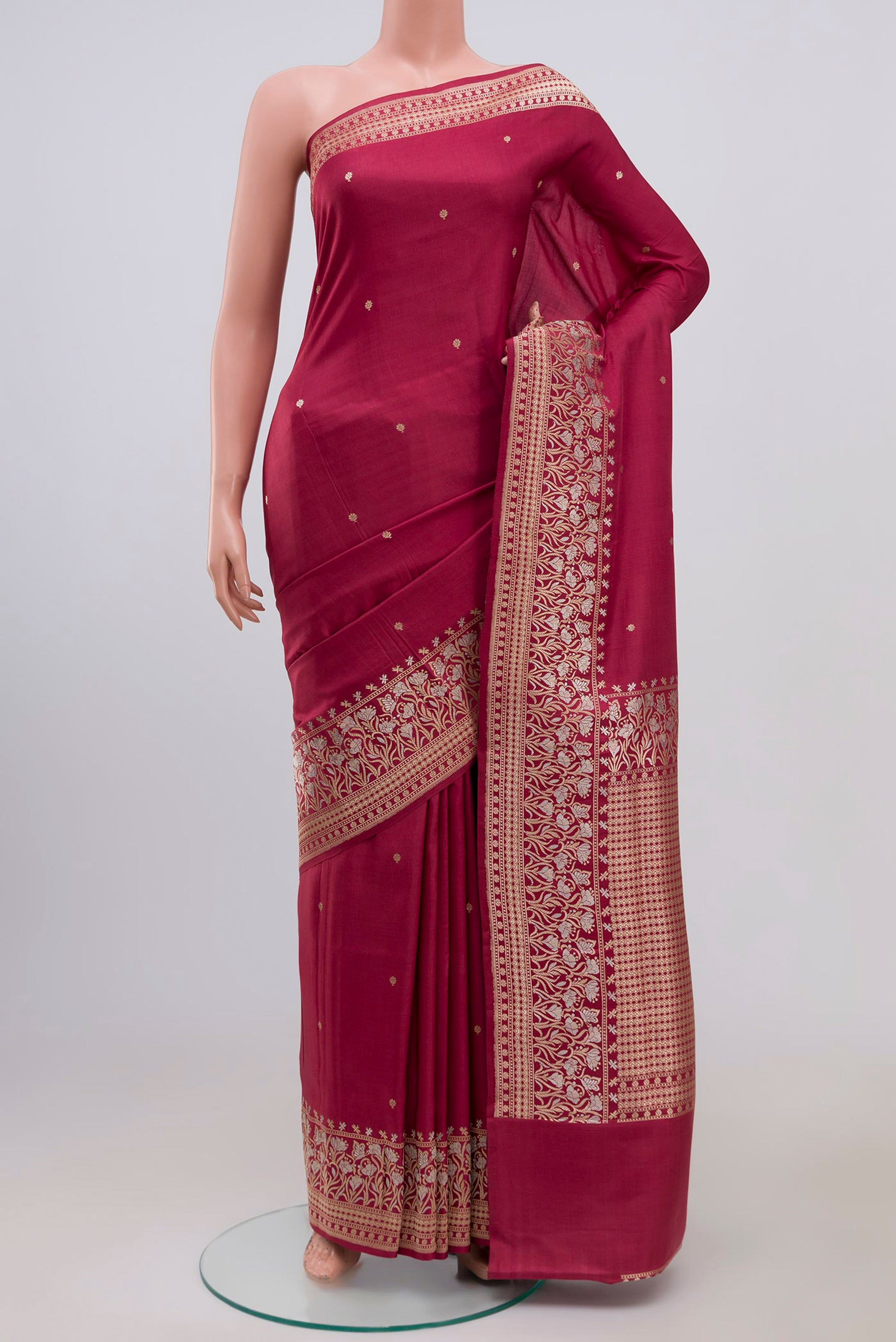 Maroon Banarasi Silk Saree with Zari Butta on the body and Zari Border.  displayed on a mannequin