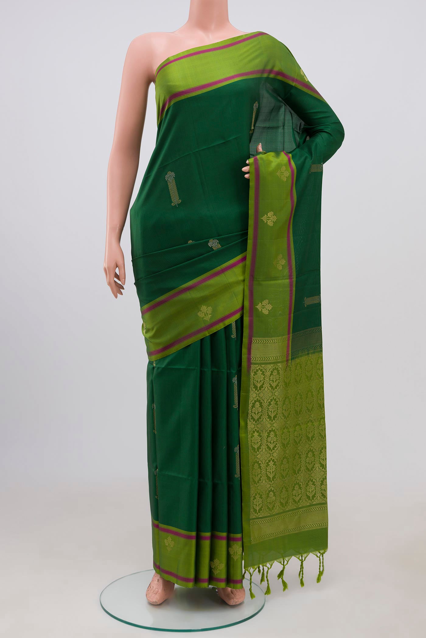 Green Soft Silk Saree with Zari Butta on the body and Fancy Border.  displayed on a mannequin