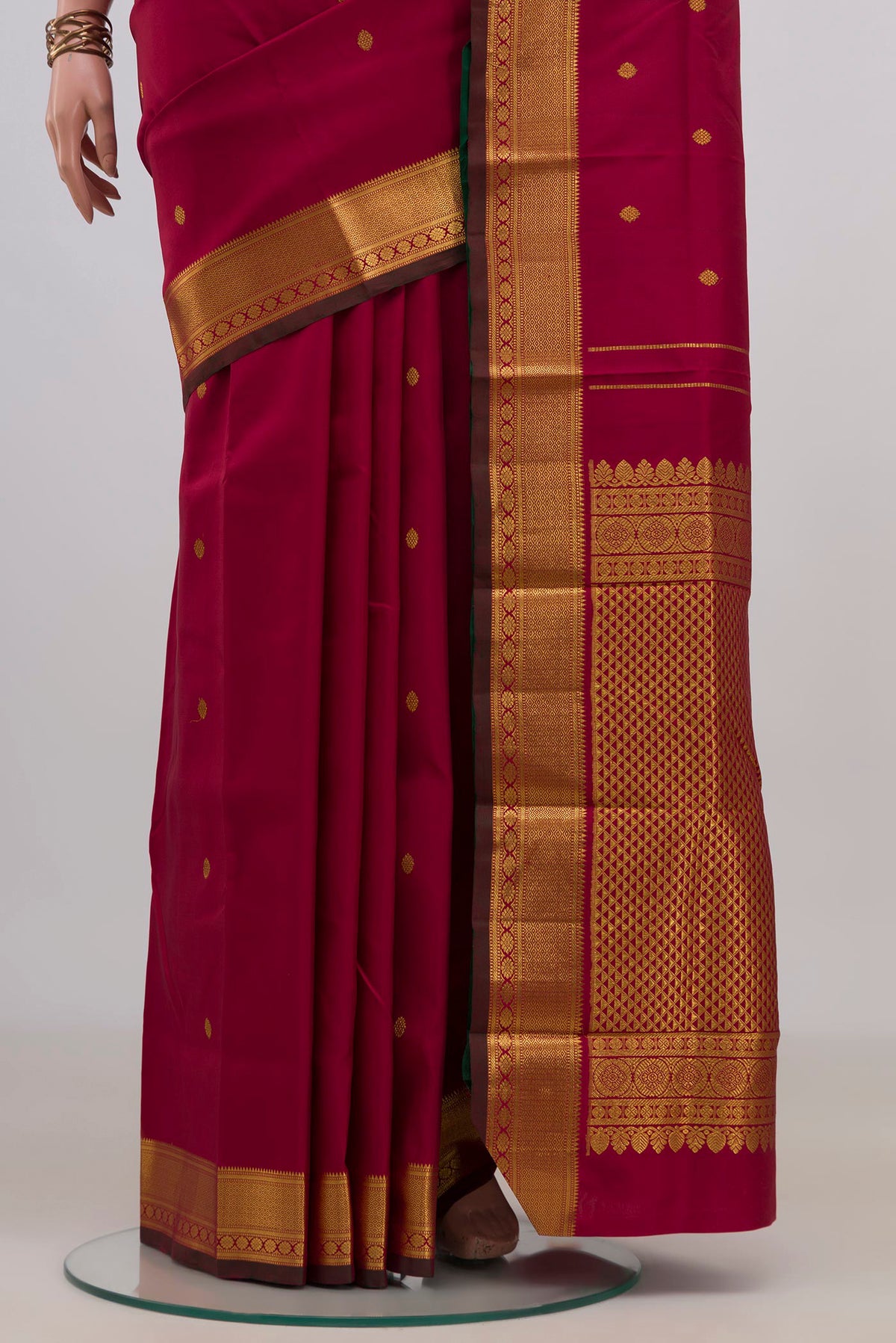 Pleats and pallu of Pure Silk Pure Zari Maroon Kanchipuram Saree with Zari Butta on the body and Zari Border. 