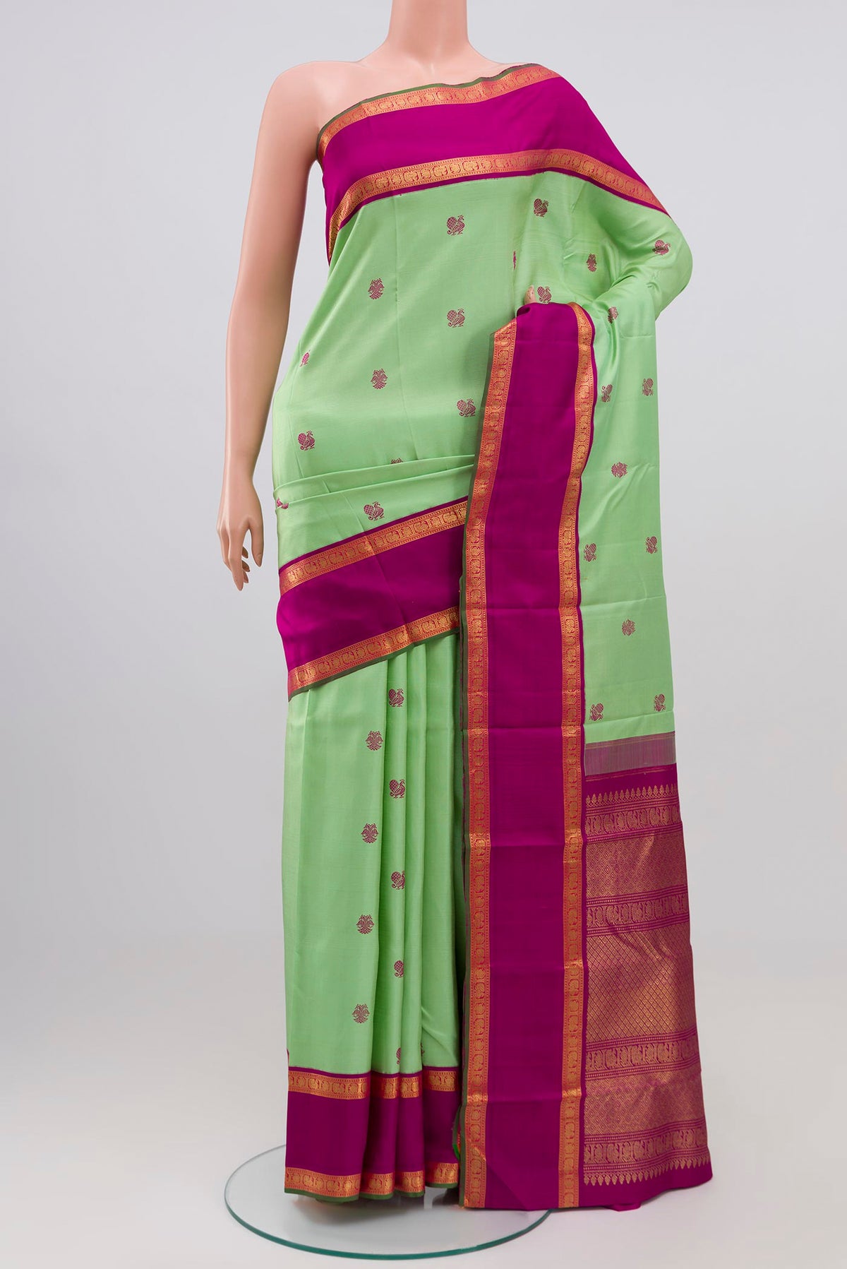 Pure Silk Pure Zari Pista Green Kanchipuram Saree with Zari Butta on the body and Zari Border.  displayed on a mannequin