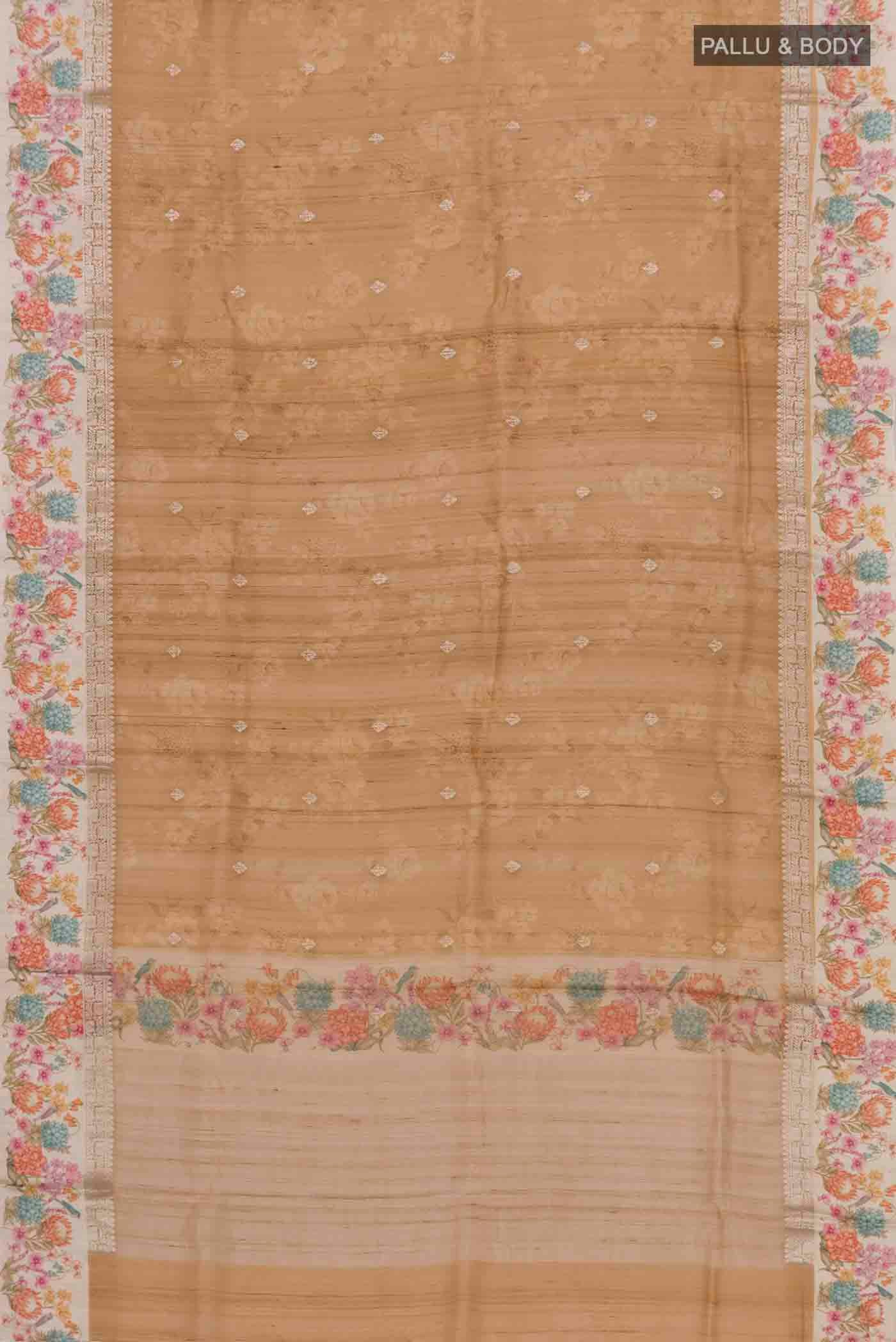 Flat view of Brown Tussar Silk Saree with Zari Butta on the body and Printed Border. 