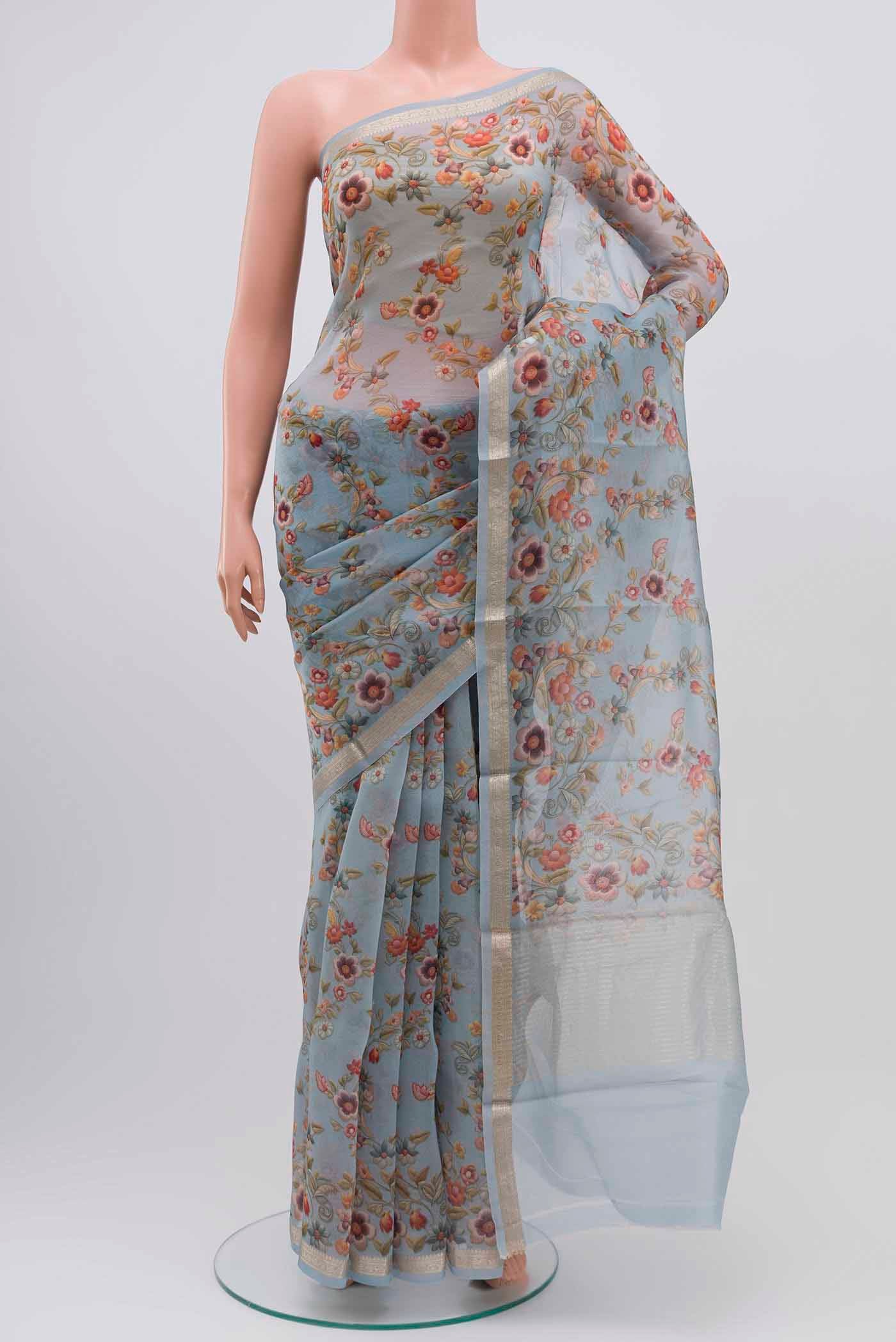 Sky Blue Organza Silk Saree with Floral Print on the body and Zari Border displayed on a mannequin