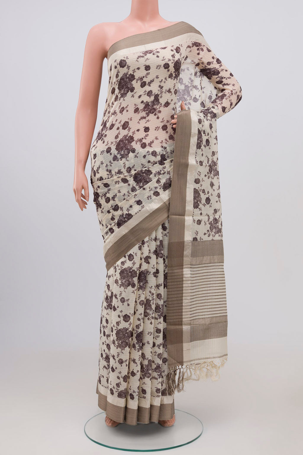 Off White Tussar Saree with Floral Print on the body and Zari Border.  displayed on a mannequin