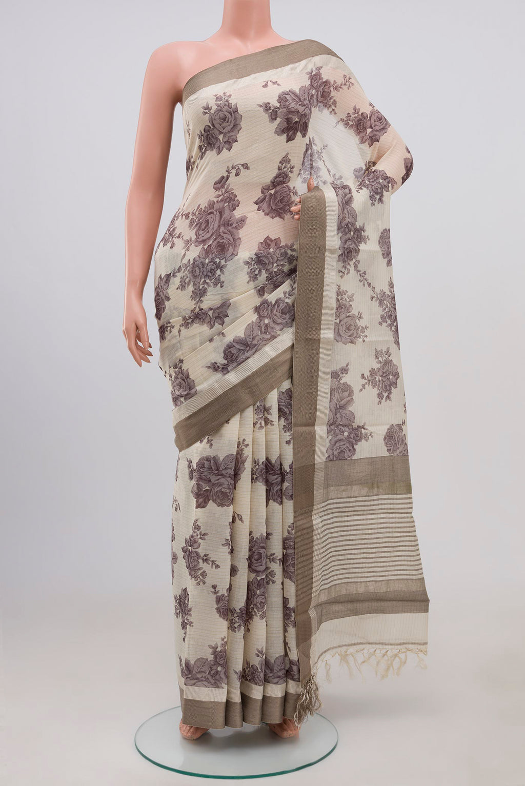Beige Tussar Saree with Floral Print on the body and Zari Border.  displayed on a mannequin